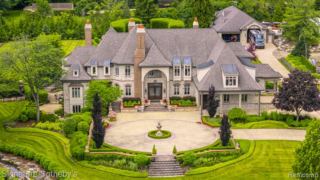 **Exquisite French Country Estate on 5.5 Acres in Northville**
Welcome to this one-of-a-kind French Country estate, gracefully nestled on 5 private acres in Northville. Behind a gated entrance, this luxurious residence combines timeless elegance with modern amenities and resort-style living. A heated exposed aggregate driveway leads to the main home and a separate 3200 SQFT finished carriage house with RV parking, complemented by a second heated and cooled multi-car garage—perfect for car collectors or hobbyists. The grounds are truly a sanctuary, featuring lush landscaping, a serene pond with a picturesque bridge and cascading waterfall, a year-round heated pool with electronic cover, two hot tubs, an outdoor kitchen with BBQ and built-in grill, and a stone fireplace ideal for entertaining. Inside, you'll find unparalleled craftsmanship and comfort with heated floors throughout, a recently updated custom chef’s kitchen, richly appointed office, sun-drenched four-season room with pool bathrooms, and a striking great room with soaring ceilings. The entry-level primary suite is a private retreat with a spa-like bath, expansive closets, and its own screened-in porch. Additional highlights include a private elevator, luxury home theater with a Rolls-Royce star ceiling, a whiskey tasting room, professional-grade home gym, steam showers, outdoor dog wash, and a built-in aquarium that adds to the home's ambiance. With top-tier security including cameras and full smart-home features, this estate offers both peace of mind and refined living. A rare opportunity to own one of Northville’s most distinguished properties—designed for those who expect nothing but the best.