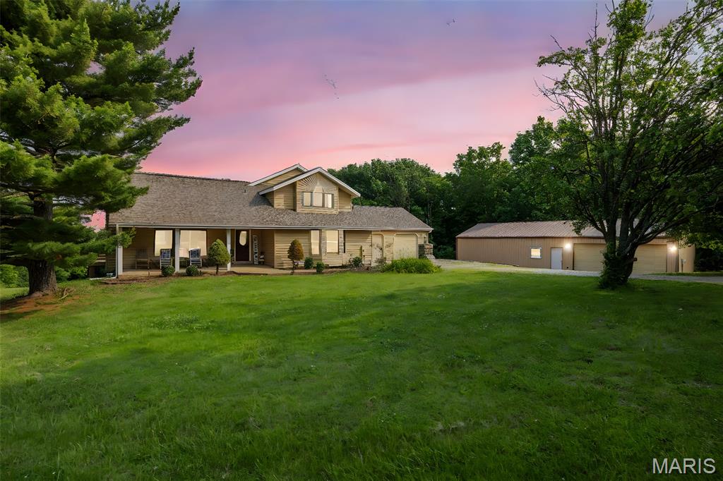 Welcome home to your own quiet private country retreat. This 4BR, 3.5 BTH 1.5 sty w/3300+SF of living space is nestled on over 6.5 acres in unincorporated St. Charles County. The picturesque exterior offers a large front porch, oversized 2 car garage w/attic storage, 2 sheds & HUGE 60'x30' outbuilding w/4 add'l car garage and tons of add'l space for a workshop, storage or other hobbies. The beautiful interior offers an open floor plan w/a spacious vaulted great rm featuring a stone WB fireplace & slider to the deck where you can surround yourself w/natures soundtrack. You'll love the kitchen with custom cabinetry, center island w/bkft bar, pantry, all kitchen appliances are included, bkft rm & LG bay window offering tons of natural light. The adjacent dining rm offers a slider to a private patio space. French doors lead you to the MF primary suite w/walk in closet & deluxe full bath w/claw foot tub & sep shower. Laundry & powder rm complete the main level. The upper lvl offers a sitting rm w/skylight, 3 BRs with vaulted and tray ceilings & full bath. The walkout LL provides you with your own home theater, exercise rm & a full bath. Nearby you'll find tons of outdoor actives w/Busch Wildlife, the Katy Trail, The historic Daniel Boone Home, Klondike Park and the vineyards of Augusta wineries.  This one is rare find and A MUST SEE!