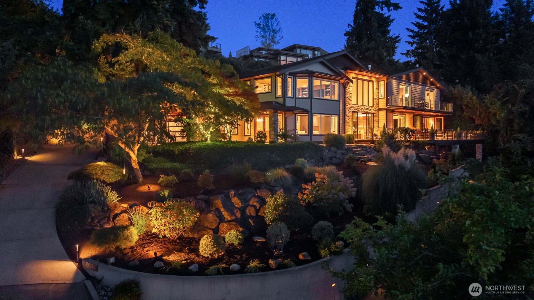Within Kirklands coveted Houghton community, a private Modern Contemporary residence embraces the Pacific Northwest in spectacular fashion! Extensively reimagined and expanded in 2015, the home balances clean modern architecture with a sense of warmth that comforts you in every season. West-facing Lake Washington and Olympic Mountain views stretch toward the horizon, creating a dramatic backdrop that evolves throughout the day before giving way to unforgettable sunsets. At the heart of the home, an expansive kitchen beneath soaring ceilings becomes a wonderful gathering place with room for multiple cooks, conversations and evenings that extend well beyond dinner. Multiple living spaces and a bedroom on the main floor offer versatility, while an intimate upper bonus room with built-in entertainment and a fireplace provides a comfortable escape. The primary wing offers spectacular views while remaining distinctly private, complete with a large suite, luxurious bath, and a balcony connected to a grand sky office. Outside, the expansive west-facing deck and gas fire pit create a natural destination to either start the morning or relax as the evening settles over Lake Washington and the Olympics. Positioned on a rare, wide, one-of-a-kind 18,471sqft lot, two driveways and three garage spaces add uncommon flexibility for various lifestyles. This home is private when you want a retreat. Expansive when you want to gather. A home designed to be enjoyed in all seasons here in the PNW.