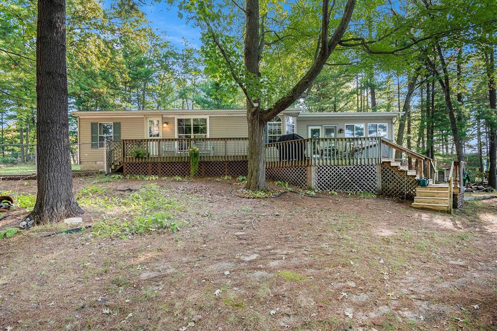 Charming Lakefront Home with Extensive Updates on Little Long Lake! This beautifully maintained 3 bedrooms, 2 bath manufactured home built in 1995 sits on the shores of Little Long Lake and offers year-round comfort with countless updates. The spacious property features a huge garage/workshop perfect for storage, hobbies, or just an area to work from home. Step inside to find a thoughtfully updated interior, freshly painted 2025, with new flooring throughout, porcelain tile 2024 and luxury vinyl 2025. The kitchen boasts updated cupboards, countertops, a cooks sink with PEX plumbing, dishwasher 2020, and microwave. The bathrooms were fully refreshed in 2023-2024 with new vanities, lighting, toilets, and plumbing. A cozy propane fireplace 2024 enhances the family room, while central air and a new furnace 2017 keep the home comfortable year-round. Major improvements include: new roof 2017 on the home, garage, and treehouse; new well and septic field 2014; new hot water heater 2020; new garage door & opener 2024; and updated exterior doors and windows. Outdoor living shines here with lake frontage, a fenced yard 2018, raised garden beds, a treehouse with new railings and steps, and even a canoe planter. Relax, garden, entertain, or enjoy the lakefront lifestyle-all from your own backyard.