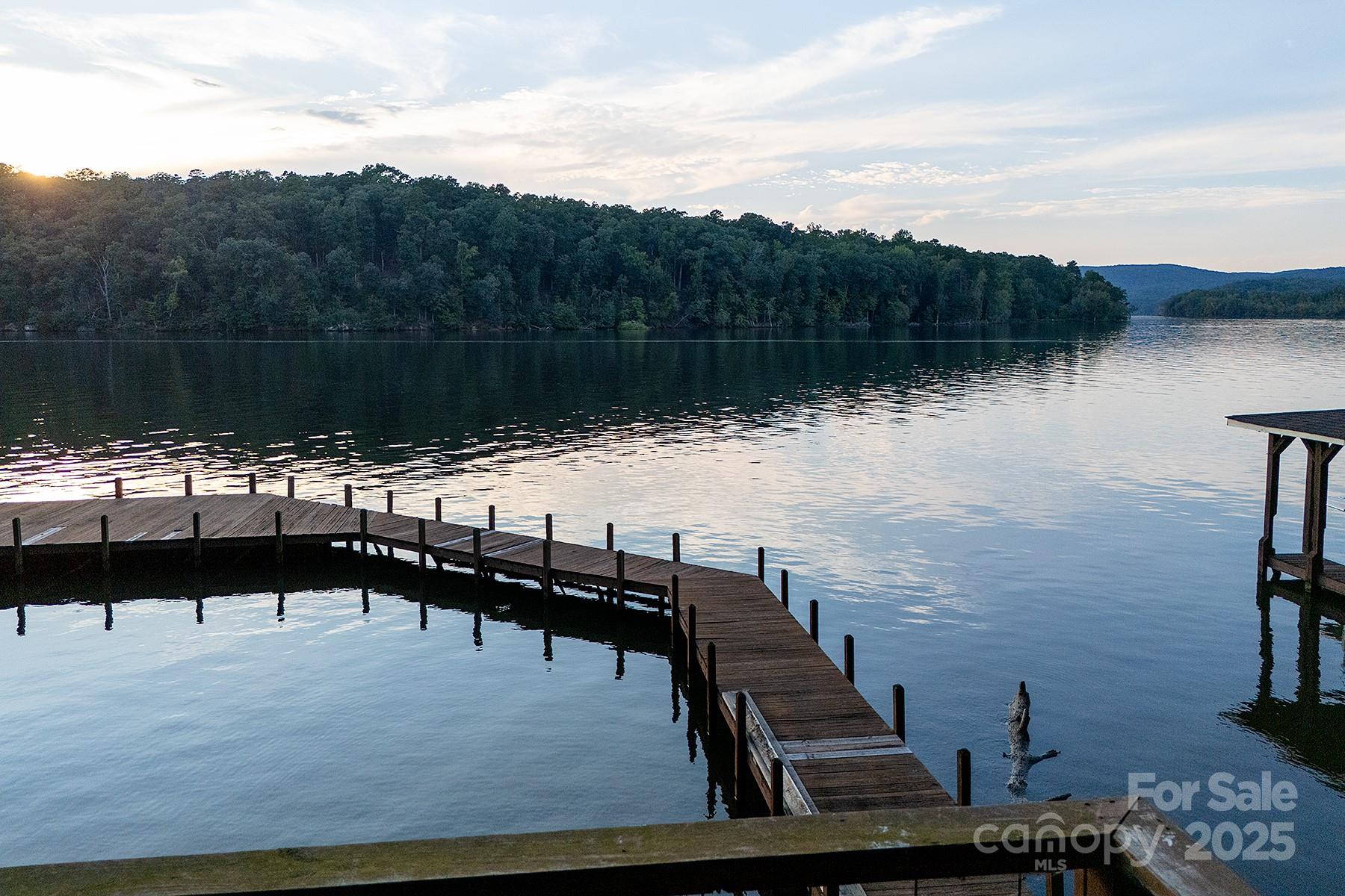 A rare opportunity on Lake Tillery! This exceptional waterfront lot comes ready for your dream home with a cleared homesite, installed driveway, and an expired 4-bedroom perc permit. The property includes two lots and a stunning gazebo that is fully appointed with ceiling fan, lamps, rugs, pillows, and seating all perched above the water for year-round relaxation. Step onto the decking and take in breathtaking views of Lake Tillery, Morrow Mountain State Park, and the Uwharrie National Forest. The boathouse is complete with a boat lift, storage, and expansive open decking, perfect for fishing, swimming, or simply soaking in the mountain and lake scenery. Level grounds with a stone path and shade trees make this retreat even more inviting. This is an unbeatable opportunity to create your lakefront sanctuary... yet the gazebo is so perfect, you may never want to build!