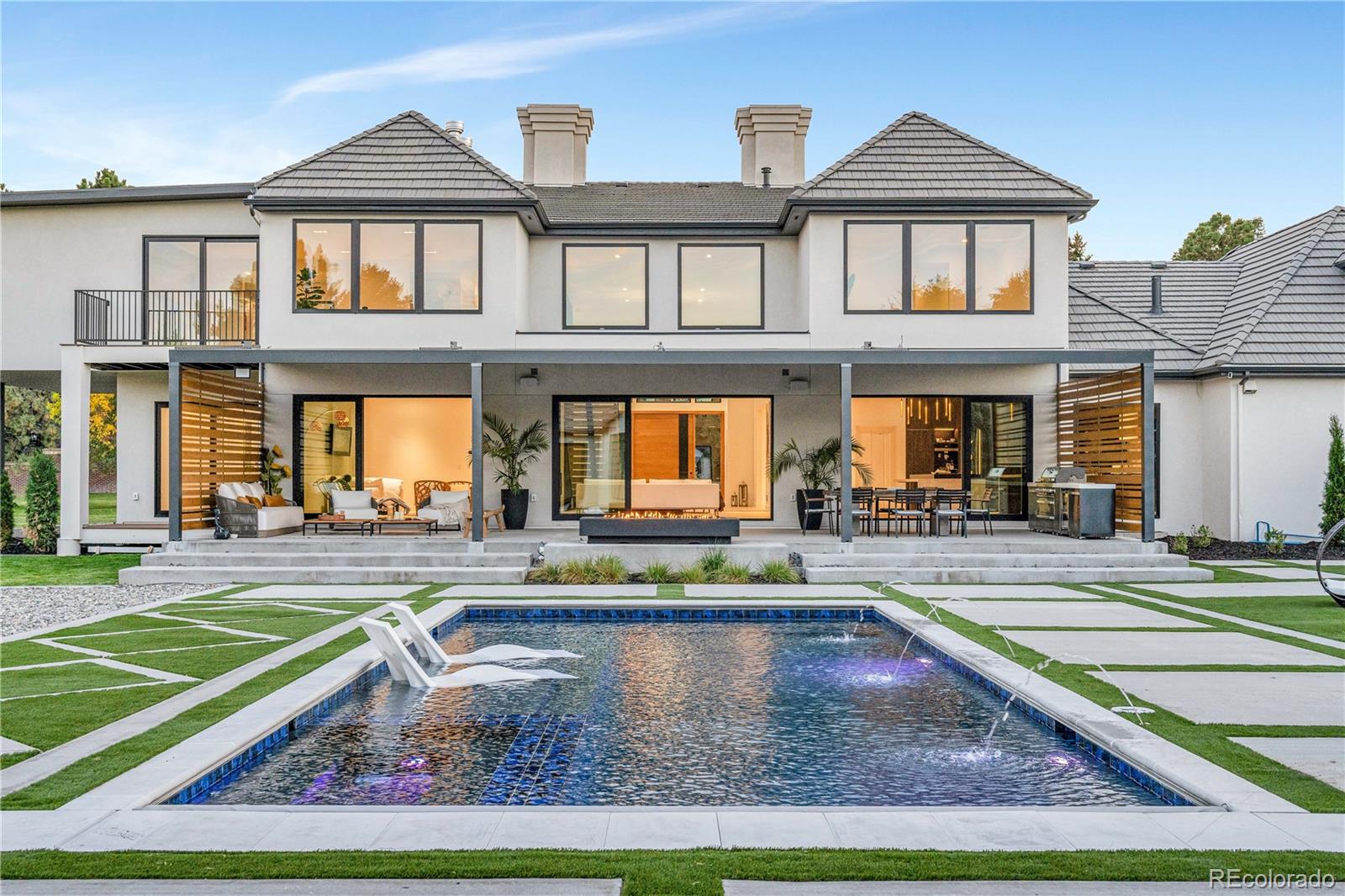 Set behind gates on more than three acres in one of Cherry Hills Village’s most coveted enclaves, this exceptional estate blends timeless architecture with modern sophistication. Completely reimagined through a meticulous studs-up renovation, the home showcases exceptional craftsmanship, quality, and effortless elegance throughout.Eight spacious bedrooms and ten beautifully appointed bathrooms offer refined comfort, while sun-filled living areas framed by walls of glass capture serene views of the lush, fully private grounds. Designed for both grand-scale entertaining and effortless everyday living, the residence strikes a rare balance between sophistication and warmth.A state-of-the-art chef’s kitchen with luxury appliances and exquisite stone surfaces anchors the main level, complemented by a separate butler’s kitchen ideal for seamless entertaining. Natural stone, bespoke finishes, and designer fixtures elevate every space, while a private elevator provides convenient access to all levels.The lower level is dedicated to recreation and relaxation, featuring a full bar, home theater, and golf simulator. Outdoors, a true resort-style oasis awaits with a pool and jacuzzi, sport court, golf practice area, and multiple outdoor living spaces—all completely shielded from neighboring views.A beautifully designed pool house with its own living area, bar, bedroom, and bath completes this one-of-a-kind retreat—offering unmatched privacy, craftsmanship, and resort-level living in the heart of Cherry Hills Village.