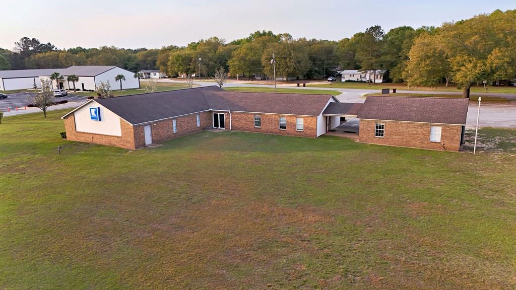 Located on 6.902 acres in Bainbridge, this exceptional multi-use commercial property offers outstanding versatility, visibility, and room to grow. Constructed with low-maintenance brick and vinyl and maintained in excellent condition, the property is move-in ready for a variety of uses with minimal modification.  Formerly operated as a church, the layout easily adapts to a daycare, professional office, medical practice, school, or training facility. The property benefits from approximately 6,800 vehicles per day in traffic count, providing strong exposure, along with ample road frontage and space for future expansion.  The grounds feature a beautiful park-like setting shaded by grand, mature oak trees, creating a welcoming environment for clients, staff, or students. There are 30 on-site parking spaces, along with convenient double-door entry at both the front and rear of the reception area.  Inside, the main 60' x 33' auditorium boasts a vaulted ceiling and offers flexible use as a training center, warehouse space, or can be built out for additional offices. Adjacent to the auditorium are two 10' x 12' offices and a 9' x 10' room, previously used as a sound booth, easily convertible into storage, an exam room, or additional office space.  The property also includes a spacious 14' x 19' break room complete with a full kitchen, ideal for staff use. Three former classroom and nursery areas provide additional flexibility for executive offices, resource rooms, or collaborative workspaces. Large restrooms accommodate both staff and guests comfortably.  A separate, fully finished 28' x 30' building is connected to the main facility by a covered breezeway, offering excellent potential as a warehouse, workshop, or additional storage.  Conveniently located just 1.4 miles from US 84 Bypass and only 6 minutes to downtown Bainbridge, this property combines accessibility, adaptability, and charm—making it a prime opportunity for businesses or organizations seeking a well-maintained, expandable facility in a highly desirable setting. Agent-measured square footage.  Buyer must verify exact heated/cooled area.