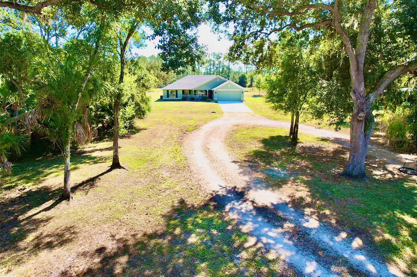 Nestled on 3 beautiful acres in the sought-after North Port Estates, this stunning 3-bedroom, 2-bathroom home, built in 2020, offers the perfect blend of modern comfort and peaceful country living. The property features a gated entryway leading to a cleared lot accented by mature oak trees and lush, established landscaping. Inside, the home boasts new solid-core vinyl flooring and hurricane shutters for added security and peace of mind. The spacious lanai provides a relaxing outdoor retreat overlooking the serene surroundings. Two well-maintained sheds offer ample storage, with one featuring a loft for extra versatility. A thoughtfully designed chicken coop adds a charming touch for those seeking a self-sufficient lifestyle. Additional highlights include generator hook-up and a desirable location along a nice, wide ditch that enhances drainage and privacy. This property offers the rare opportunity to enjoy space, tranquility, and modern convenience—all just minutes from the heart of North Port.