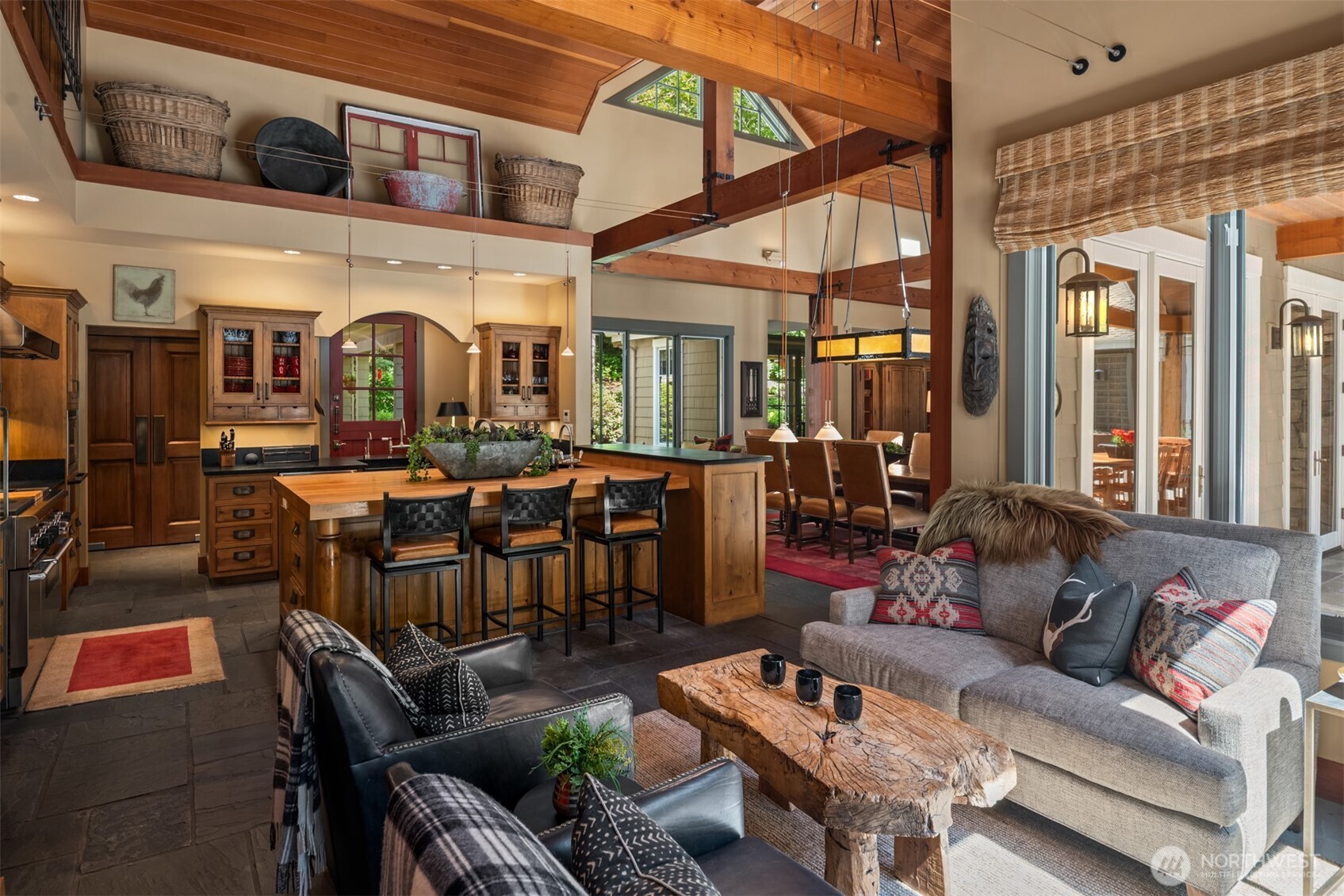 Kitchen opens to family room with leather seating and stone accents