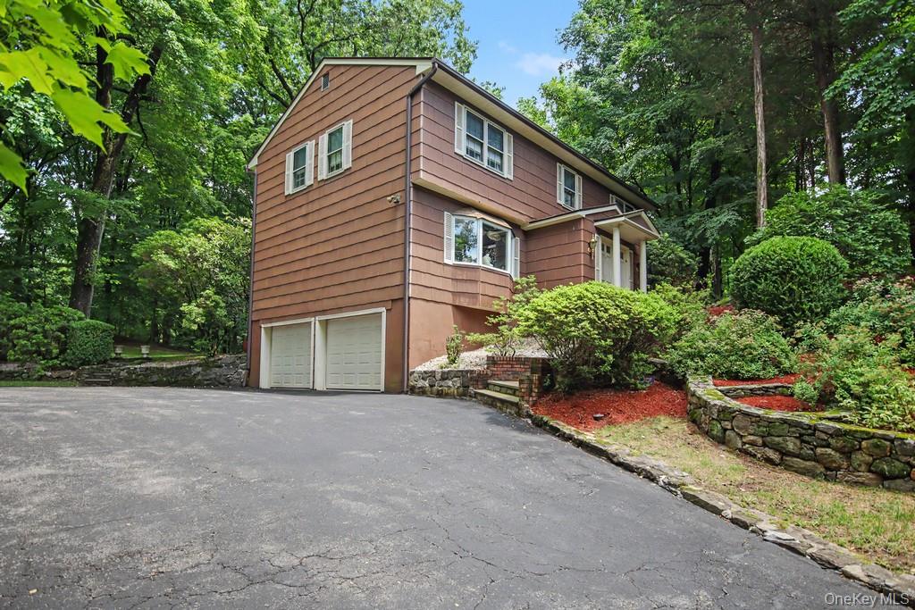 Nestled well back from the road, this classic Colonial offers privacy, peaceful surroundings, and a spacious rear yard. A grand double-door entry welcomes you into a marble foyer accented by elegant stained-glass paneled windows.  The eat-in kitchen features granite countertops, a tumbled marble backsplash, warm wood cabinetry, convenient first-floor laundry, and a sliding glass door leading to a newly painted rear deck—perfect for outdoor dining or relaxing while overlooking the tranquil backyard.  The inviting family room is highlighted by a charming brick fireplace framed with stained-glass accents. The bright living room, featuring a bay window, flows seamlessly into the formal dining room, creating an ideal space for entertaining. A powder room and beautiful parquet flooring complete the first floor.  Upstairs, you'll find four generously sized bedrooms, including a spacious primary suite with his-and-hers closets—one a walk-in—and an updated en-suite bath with an oversized walk-in shower. The hall bathroom offers a double vanity and a tub/shower combination.  Additional features include updated central air conditioning, a new attic access door, and an underground sprinkler system. The lower level provides access to the attached two-car garage and includes a semi-finished bonus room along with a hot tub, offering additional space for recreation or relaxation.  Step outside onto the rear deck and take in the peaceful, private setting. Conveniently located just 5 minutes from the Cortlandt train station, with an approximately 45-minute commute to New York City, this home offers the perfect balance of suburban tranquility and city accessibility. There are no audio recording devices inside this property.
