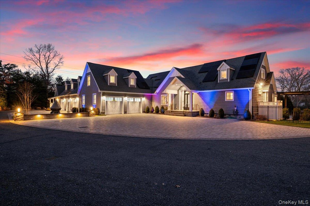 Set beyond a gated driveway and surrounded by mature landscaping, this recently renovated residence offers over 10,000 sq ft of interior living space across three levels; a scale rarely found in Hampton Bays waterfront homes. The property blends modern upgrades with direct water access, expansive outdoor living, and exceptional privacy, creating a setting well suited for multi-generational living, entertaining, or extended seasonal stays.The main level features a glass conservatory, chef’s kitchen with Thermador appliances, a first-floor primary suite with access to the three-season deck, an additional en-suite bedroom, a third bedroom, powder room, and laundry. The second floor includes five bedrooms, highlighted by a secondary suite with two walk-in closets, an en-suite bath, and a private balcony overlooking the water. Two additional full bathrooms support flexible guest use. The lower level offers an 8-seat movie theater, arcade room, and storage areas designed for extended living.  A separate two-level accessory apartment includes one bedroom and one bathroom; ideal for guests, live-in support, or potential rental income, adding versatility to the property’s layout.  Outdoor amenities include a gunite heated pool, hot tub, outdoor kitchen, and multiple lounge areas that create a seamless indoor-outdoor environment for dining and gathering. Waterfront features include a boat lift, direct canal access, and open water views from several vantage points. Additional features include a heated 5-car garage, solar panels, Tesla backup battery with dual chargers, and central vacuum.  With its combination of interior scale, updated systems, extensive amenities, and waterfront access, this property represents a rare opportunity for expansive Hamptons living in a highly functional and well-connected setting.