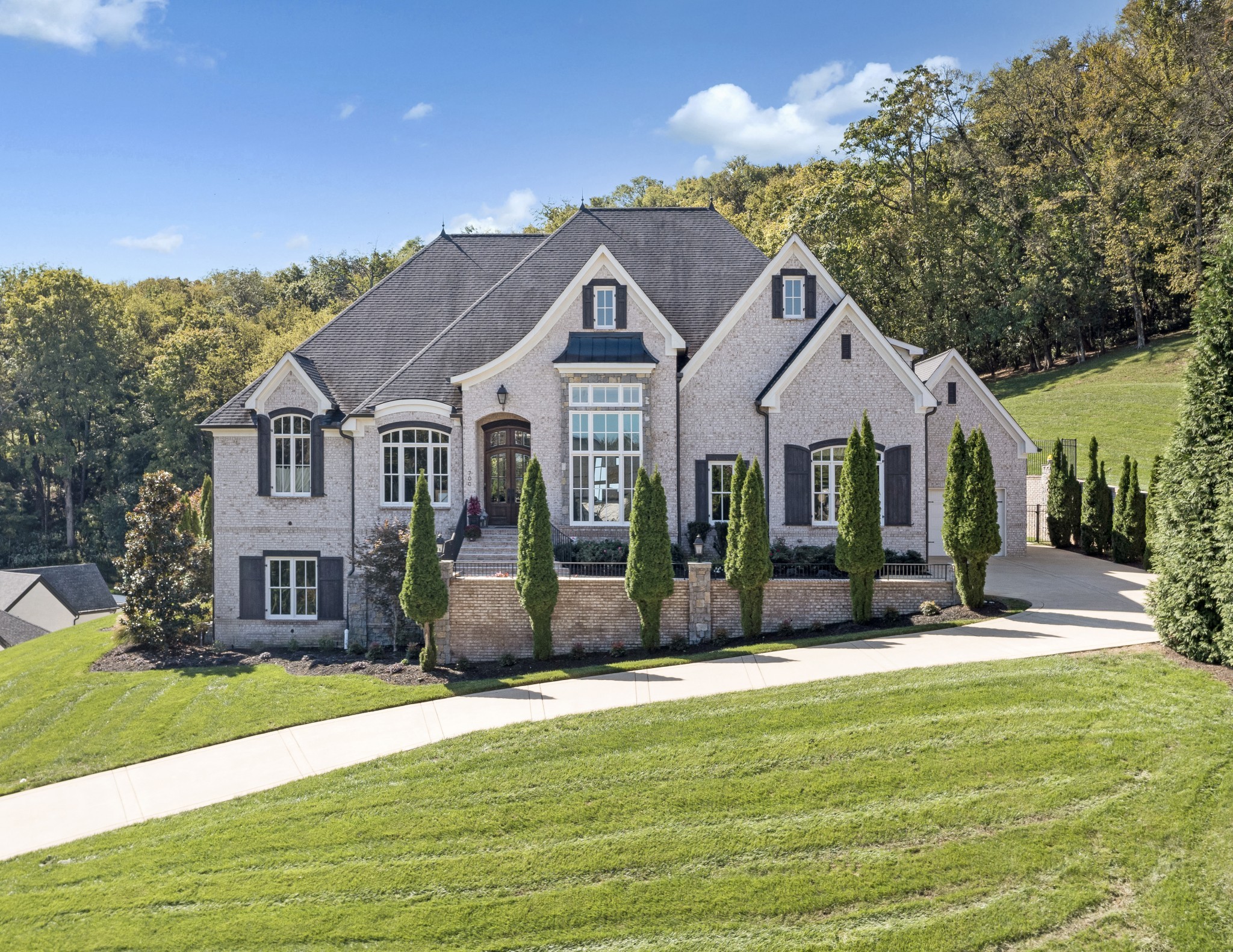 Luxury living at its finest! Welcome to this magnificent 6BR/5.3BA home perched atop a hill in the exclusive gated community of Avalon | Nestled at the end of a 1.89 acre cul-de-sac lot w b/reathtaking views of the TN hills and backing up to a private wooded area, this home affords an abundance of privacy | This thoughtfully curated home truly has it all from an open concept floorplan w/ spacious room sizes, to a secluded resort-style pool & outdoor living vista to a walk-out lower level that includes a media room, FR w/ full wet bar & wine room | Upon entering, the office features a coffered ceiling & a wall of built-in shelving | DR is enhanced by quality mill work &  a wall of windows w/ hill views | The expansive GR is highlighted by a flr-to-clg stone gas frplc surrounded by built-ins & accented w/ a wood inlay coffered ceiling | You'll love hosting family & friends in the culinary dream kitchen boasting a huge island w/ farmhouse sink, Wolf appliances including double ovens, gas cooktop, warming drawer & m/w plus a Sub-Zero Frig + a beverage bar & large pantry | Get lost in luxury in the Owner's Suite featuring a sitting room overlooking the pool & hills, and a spa-like bathroom w/ soaking tub, extended separate vanities & two walk-in closets | Main flr en-suite bedroom has direct access to the pool area | Upstairs find en-suite 3BR & 4BR-5BR sharing a jack-n-jill bath plus a large bonus room & loft area | Finished lower level features a family room w/ gas frplc, game room with full wet bar & doors to the fire pit patio, a fully equipped Home Theater, an en-suite 6BR/exercise room, and a wine room with 200+ bottle capacity | The resort-style living continues as you enter the backyard vista featuring a heated Rondo infinity pool & hot tub, outdoor kitchen with gas grill,
