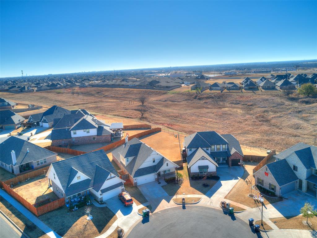 This beautifully maintained Edmond residence has 2056' with Tall 10'Ceilings has 3 Beds,3.5 Baths, 3 Car Garage, 2 Living Areas, & a Large Open Kitchen with a Large Island with Stainless Appliances & White Quartz Countertops. This home offers the perfect blend of elegance, comfort, & modern living with crown molding for detail.  Nestled on a culdesac in the back of the neighborhood, this home backs up to greenbelt with no homes directly behind you & a see through wrought iron fence looking onto the greenbelt! Large oversized Lot & the  Upstairs is only a 2nd Living Room/Bonus Room/Media Room with a Full Bath. All Bedrooms are Downstairs. When you step inside to soaring ceilings, abundant natural light & an open thoughtfully designed floor plan that enhances both daily living & entertaining.  The home has 2 Fireplaces: Gas Log Fireplace in the Downstairs Living Room (open to Kitchen) & the Outdoor Fireplace is Wood Burning on the Covered Patio. A Tankless Hot Water Tank, Sprinkler System, & a Storm Shelter are all in the garage. Garage is a 3 Car with one Bay being a tandem (double) space for the third space. The Primary Bedroom suite is a true retreat boasting a spa inspired ensuite with two vanities/sinks, Large Tub, separate shower & toilet (water closet), & large Walk-in Primary closet to fill up! Outside enjoy Oklahoma sunsets on the covered patio overlooking a well maintained backyard- ideal for pets, play, or simply unwinding! Located in Edmond, Oklahoma & Blue Ribbon Award Winning Deer Creek Public Schools, this home has easy access to Highway 74 & Kilpatrick Turnpike, restaurants, shopping, & all the amenities of North OKC & Edmond. This home offers unbeatable value, in one of the most desirable areas in the metro! Immaculate Condition with Exceptional Layout & Location! The Grove has a Fitness Centers, 2 pools, a lake with walking trails, multiple parks, and greenbelt. Call now to set up a showing!