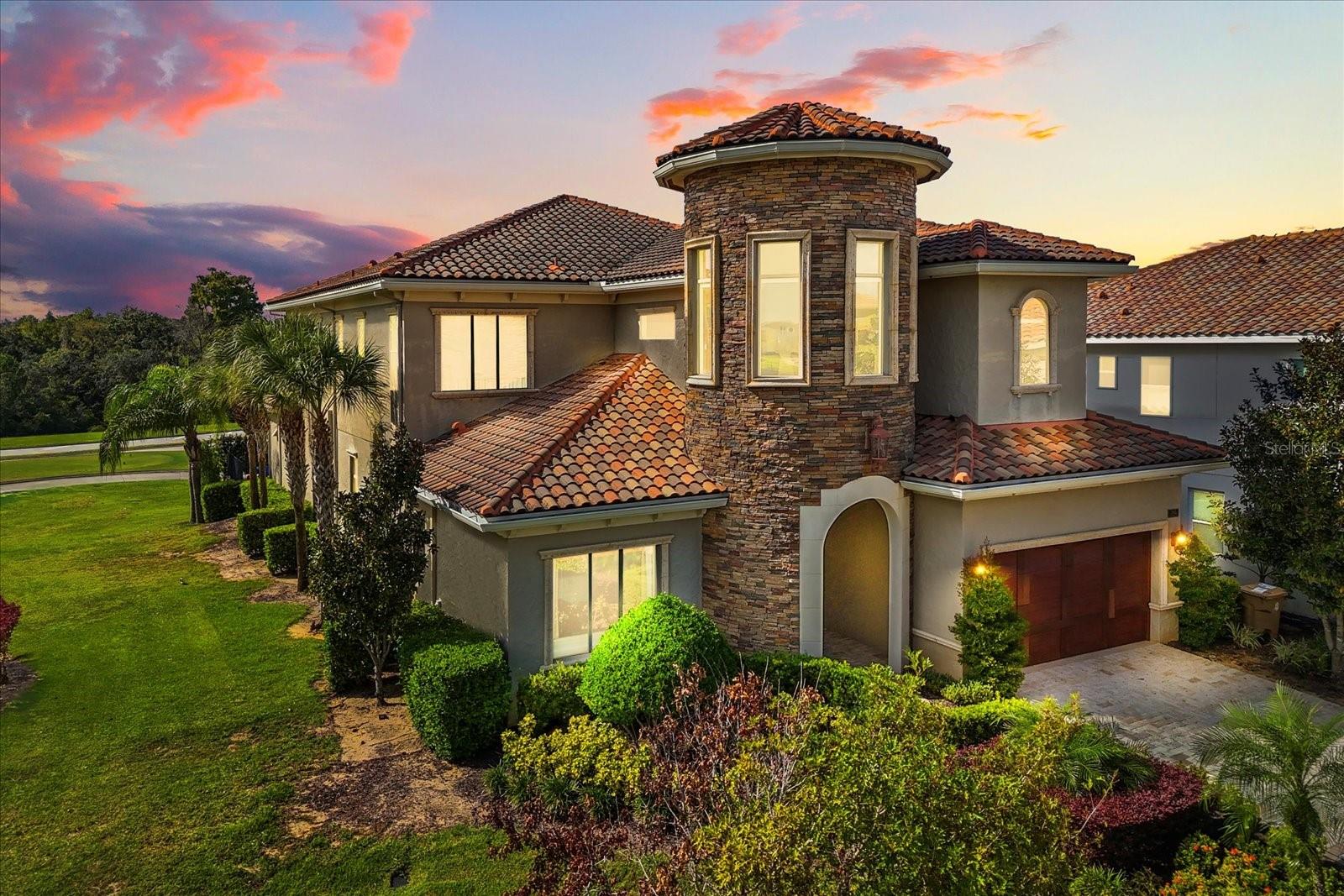 This is a one of a kind, Architectural Masterpiece, custom built by one of the original luxury builders in Reunion Resort’s most coveted location in Central Florida.  This exquisite property is positioned on a corner lot along the 12th tee of the iconic Jack Nicklaus Signature Golf Course. As you walk through the grand 10-foot wrought-iron double doors, a world of sophistication unfolds. Every detail has been meticulously curated—from the bespoke millwork to the thoughtfully designed floor plan that effortlessly blends form and function. The main level features a richly appointed executive office with custom built-ins and an expansive owner’s suite, complete with private access to the outdoor oasis. The open-concept living area includes a chef’s kitchen with high-end appliances, a gracious dining space, and a stylish great room, all opening seamlessly to the outdoor entertaining terrace. The outdoor living experience rivals that of a five-star resort. Anchored by an oversized pool and elevated spa, this space boasts a double-sided gas fireplace, fully equipped kitchen with built-in grill, outdoor television, private pool bath, and retractable motorized screens—creating a luxurious yet comfortable setting for year-round entertaining.The upper level is equally impressive. Four generous guest suites each feature private en suite baths, offering elevated comfort for family and guests. An opulent 12-seat home theater with plush recliners and a custom wet bar offers a true cinematic experience, while the upstairs lounge—with billiards area—opens to a sweeping balcony with panoramic golf course views. This exceptional residence is being offered with an active Reunion Club membership, granting access to the community’s world-class amenities: 3 Signature Championship Golf Courses, a private 5-acre water park, mini golf course, tennis and pickleball courts, six on-site restaurants, two fitness centers, and so much more~! ** ALL 4 HVAC SYSTEMS REPLACED IN 2023!**Schedule your showing TODAY!