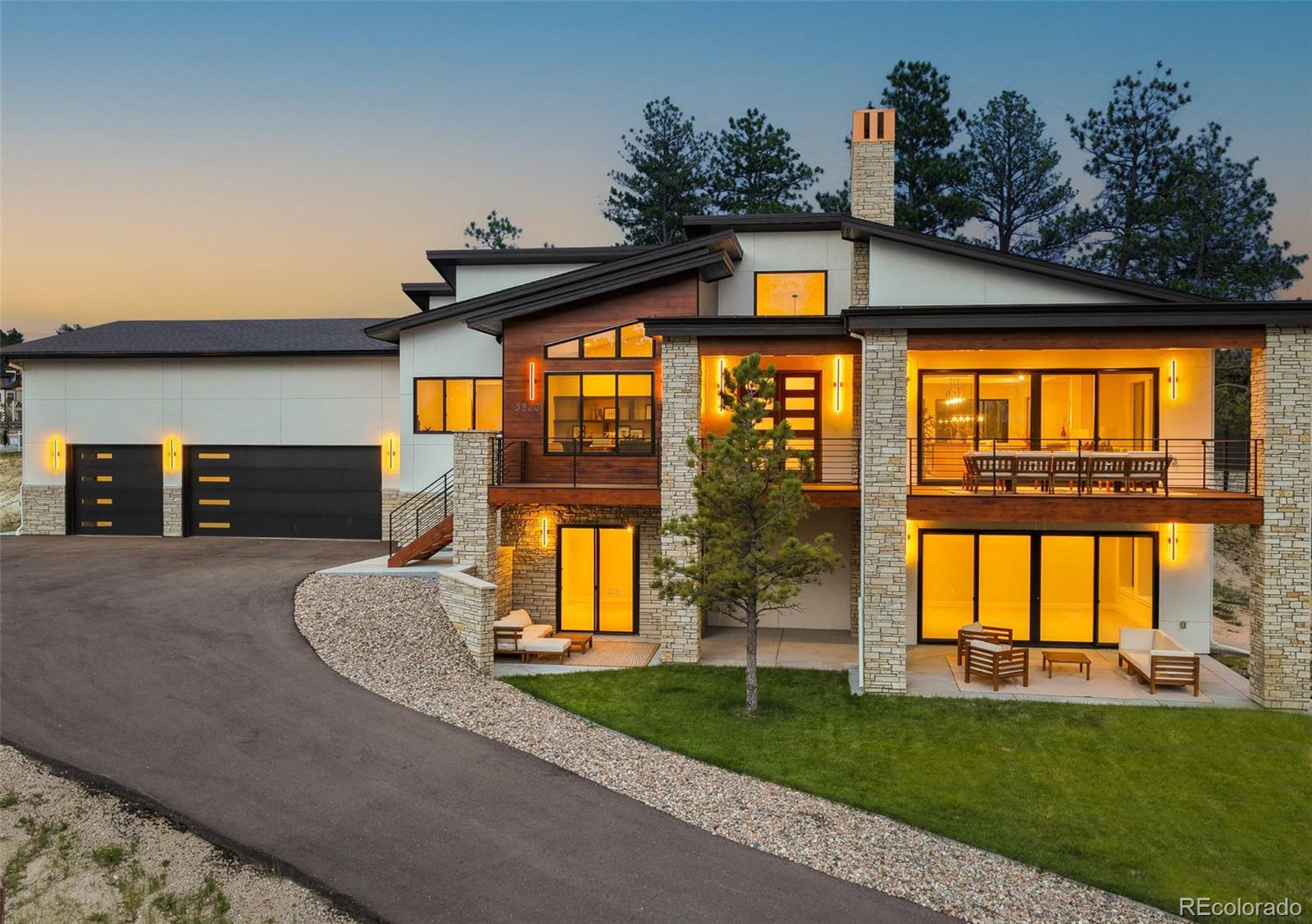 Designed to live beautifully from front to back, this mountain contemporary ranch pairs welcoming architecture with a highly functional floor plan that feels open, comfortable and well considered. Built in 2025 by Summerwood Homes in The Timbers at The Pinery, the residence offers over 5,400 total square feet, four bedrooms, six baths and spaces created for both everyday living and effortless entertaining.The main level is defined by volume, light and connection. Expansive windows frame the setting, while a dramatic floor-to-ceiling fireplace anchors the great room. The kitchen combines custom cabinetry, quartz surfaces and designer appliances with an oversized island, walk-in pantry and fully equipped back kitchen featuring additional refrigeration, a dishwasher and generous prep space. The dining area and outdoor living spaces extend the home beyond its walls, creating an easy flow for intimate evenings or larger gatherings.Privately positioned on the main level, the primary suite includes a beautifully finished five-piece ensuite, expansive glass shower, freestanding tub and substantial walk-in closet. A dedicated office, powder room, laundry and mudroom complete the level.The finished walkout lower level expands the home with three additional bedrooms, each with an ensuite bath, a spacious family and recreation area, custom wet bar with wine display and a versatile flex room suited for a theater, fitness studio, or game room. Outside, professional landscaping, a built-in fire pit and multiple places to relax or gather connect the architecture to the landscape.The oversized three-car garage is equally intentional, offering exceptional depth and 14-foot ceilings with room for full-size trucks, storage, hobbies, or vehicle lifts. Set on a .5-acre in a quiet cul-de-sac, 5820 Powell Road delivers refined materials, strong architectural character and a floor plan designed not simply to impress, but to live well. View More At: https://www.5820powellroad.com