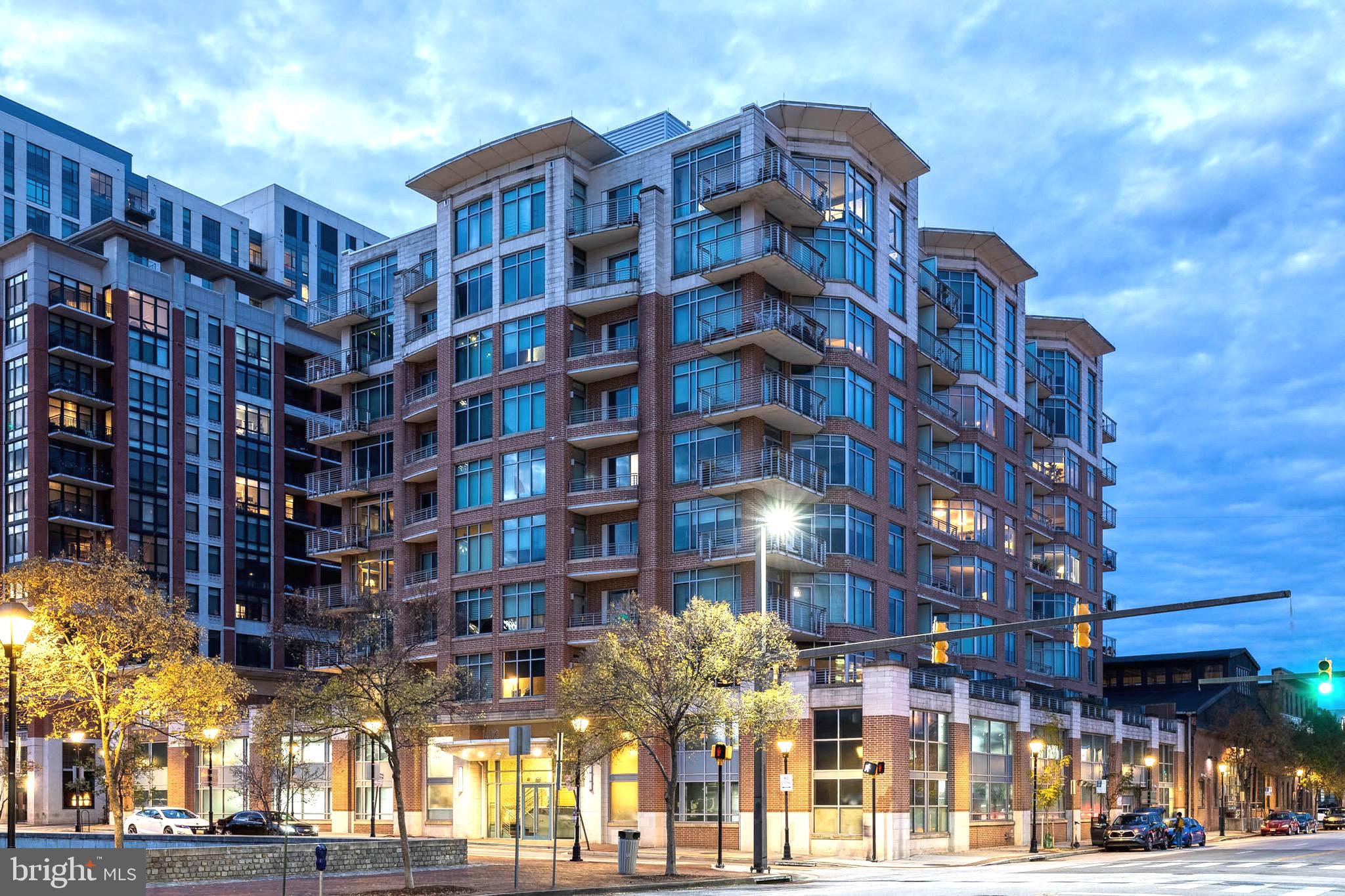 Meticulously maintained (1853 sq. ft. of living space), turnkey,  2 level, 2 bedroom, 2.5 baths, east facing light filled unit with walls of windows in living room,  dining room and primary suite.  Gourmet kitchen features granite counters, breakfast bar,  double sink, weave tiled back splash, garbage disposal, wall oven/microwave and gas range.  Main level office (exclusive of this unit).  Engineered hardwood flooring throughout and radiant heated floors on main level.   Large patio off dining room, (grills allowed), views of historic Fells Point.  Upper level includes 2 Bedroom Suites with En Suite Bathrooms. Primary bedroom faces east,  walk out to a large balcony and relax, unwind and enjoy the views.  Spa like primary bathroom features corner jetted jacuzzi tub, double sink with granite counter, travertine tile floor and walk in shower. Laundry room is easily accessed by both bedrooms.  2nd bedroom includes balcony access,  lots of natural light from east facing windows, walk in closet providing room for storage.  Upgrades include: HVAC/gas heat system (2 years),  custom blinds, neutral color paint throughout.  Secure assigned garage parking with secure storage area.  Need parking for guests?  There is a list available to owners of units that  have parking spots available if needed.  A fine feature of this building is the on site security staff and concierge service.  Enjoy the maintenance free lifestyle this amazing property has to offer.  Walk or bike ride to restaurants, shopping and entertainment.  Easy to Show! Showings are confirmed immediately!!