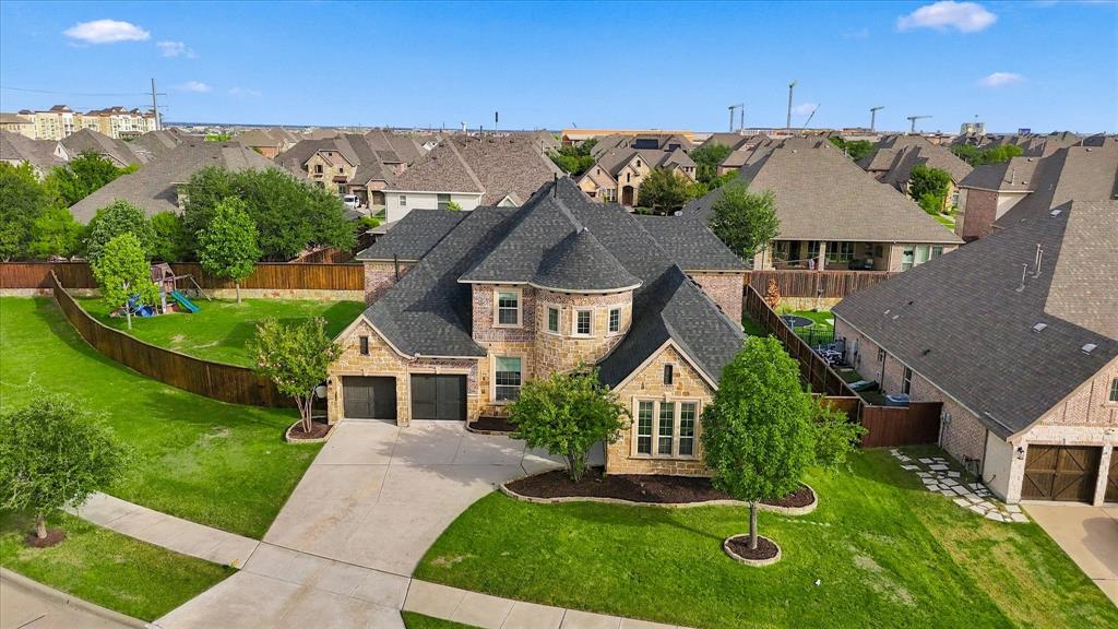Situated on an oversized 0.385-acre corner lot, this stunning residence makes an unforgettable first impression with its striking stone façade, three-car garage, and impressive custom Pella front door. Step inside to discover soaring ceilings, sophisticated finishes, thoughtfully designed living spaces, and exceptional upgrades that seamlessly blend elegance with everyday comfort. Beautifully refreshed interiors showcase fresh paint downstairs, plush new carpeting, and rich hardwood floors. Designed for both grand entertaining and comfortable everyday living, the spectacular open-concept living area features a dramatic wall of windows that bathes the space in natural light. At the heart of the home, the impressive chef-inspired kitchen boasts an expansive center island with abundant seating, generous counter space, a gas cooktop, double ovens, extensive cabinetry, and exceptional storage, spacious walk-in pantry and convenient butler's pantry. A private study offers an elegant work-from-home retreat, while the spacious downstairs guest suite with its own en-suite bath provides comfort and privacy for visiting guests or multigenerational living. Upstairs, an expansive game room, dedicated media room, and two generously sized bedrooms offer versatile spaces for relaxation and entertainment.  Step outside to an exceptionally spacious backyard offering endless possibilities! The covered patio provides the perfect setting for outdoor gatherings, while the expansive yard offers ample room to create your dream outdoor retreat. This incredible blank canvas is ready to become your own private oasis!  Ideally located just minutes from the new Universal Kids Resort and PGA Frisco, with access to the Cobb Farms Amenity Center, this exceptional property offers the perfect combination of luxury, space, convenience, and lifestyle. Upgrades: 2025 roof, French drains, commercial-grade Wi-Fi, Vivint security with cameras, carbon monoxide detector, garage door & thermostat controls.