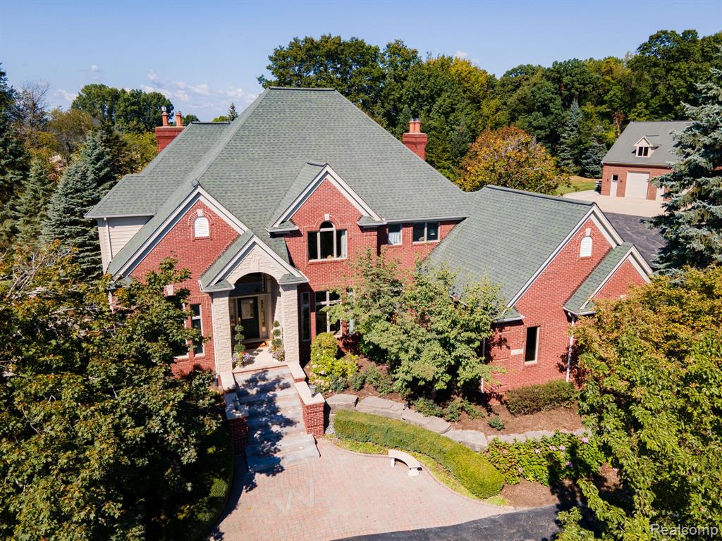 Welcome to this extraordinary estate in Washington Township, set on a serene and picturesque 5.5+ acres.Offering 6 bedrooms, 6 full bathrooms, and 2 half bathrooms, this home combines timeless elegance with modern amenities for both everyday living and entertaining. A fully equipped kitchen seamlessly opens into the great room, while a separate dining room provides privacy for formal gatherings. The first floor also features a spacious living room and a library connected by a stunning wet bar. Upstairs, the luxurious primary suite boasts a spa-like ensuite with a generous walk-in closet. Three additional bedrooms are located on the second floor—one with a private ensuite bath, and the two others with an additional full bathroom. A finished attic offers flexible space, perfect for a game room, office, or hobby area. The walkout basement features a full kitchen, family room, bedroom, full bathroom, and ample storage. Outdoors, enjoy tranquil views of the private pond and waterfall or relax by the heated saltwater pool. The limestone pool house, complete with a full bathroom, adds convenience after a day in the sun. Car enthusiasts will love the expansive 9+ car garage, while guests will feel right at home in the spacious apartment above. Ideal for overnight visitors, this private retreat includes a large living area, full kitchen, bedroom, laundry room, and full bathroom. Additionally the garage level features a half bath. From its thoughtfully designed interiors to its resort-style grounds, this estate offers year-round comfort, luxury, and entertainment.