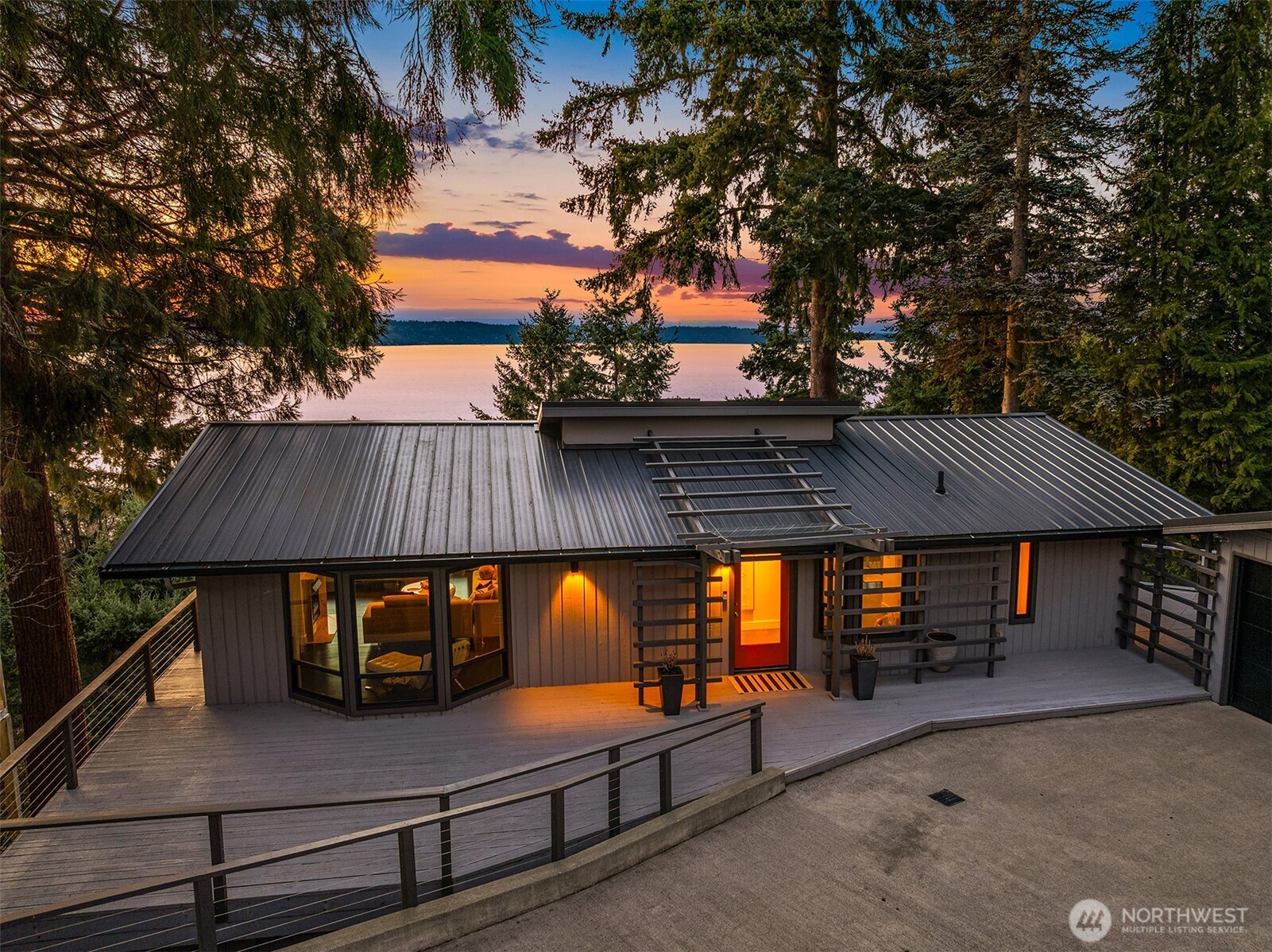 Perched on the quiet western slope of Three Tree Point, this fully reimagined mid-century retreat captures sweeping Puget Sound and Cascade Mountain views from nearly every room. Surrounded by trees for exceptional seclusion, the home blends sleek modern design with effortless comfort. The open, light-filled main level showcases vaulted ceilings, skylights, radiant heated tile floors, custom smoothed walls, and expansive windows framing the water. The entertainer’s kitchen features a large peninsula, eat-in island, glass-front Sub-Zero refrigerator, double wall ovens, walk-in pantry, and views from the cooktop. Dining space and a stylish powder bath complete the level. All three bedrooms are positioned together downstairs. The spacious primary suite offers stunning views, deck access, and a spa-inspired bath with soaking tub, dual-head shower, and custom walk-in closet. Two additional bedrooms and a full bath complete this floor. A versatile 600 sq ft lower level with private exterior access offers ideal ADU or multi-generational potential, currently built out with additional living space, fitness area, and wine storage. Enjoy over 1,500 sq ft of wraparound deck space. Set on a generous 19,000 sq ft lot with potential to build, plus a 2024 metal roof, foam insulation, detached 2-car garage, and ample driveway parking, this is turnkey view living at its finest.