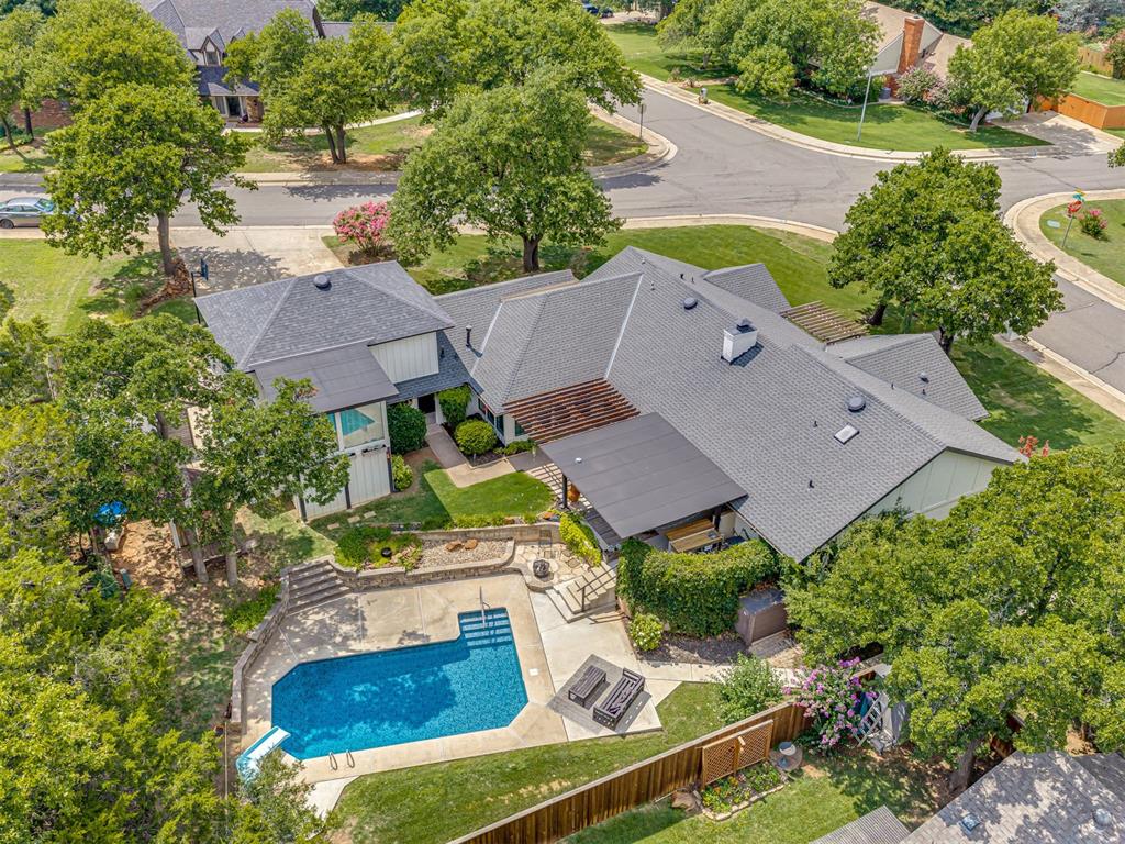 SHOWSTOPPER on a HUGE corner cul-de-sac lot with a sparkling inground swimming pool and private guest quarters featuring a separate entrance! Whether you're looking for the ultimate work-from-home space, guest suite, private apartment, creative studio, or multigenerational living, this one-of-a-kind property offers flexibility that's nearly impossible to find.Just off the garage is an additional finished room that would make a great study, hobby room, homeschool space, or second home office. The oversized garage also features built-in storage cabinets along two walls, providing plenty of space to stay organized.Inside the main home, you'll find four bedrooms, two living areas, and a beautifully remodeled kitchen featuring granite countertops, painted cabinetry, updated lighting, and newer flooring. One living room is centered around a beautiful fireplace with custom built-ins, while the second living area offers additional space for relaxing or entertaining. The primary suite features double vanities and a walk-in closet. Two of the secondary bedrooms are connected by a Jack-and-Jill bathroom, while another secondary bedroom enjoys its own private full bathroom, creating a great layout for guests.The backyard is an entertainer's dream! The covered patio overlooks the sparkling inground pool and features a wet bar, making it the perfect place to host family and friends. Additional outdoor features include a greenhouse, playhouse, lush landscaping, an inground sprinkler system, and a new pool pump.Updates include windows, interior and exterior paint, flooring, lighting and plumbing fixtures, kitchen and bathroom countertops, the covered patio, front porch pergola, shutters, sidewalks and additional flatwork, pool liner, and more.Neighborhood amenities include a pool and tennis court!Properties with this much flexibility, separate living space, storage, and room to grow rarely come available. Don't miss your chance to make this one yours!