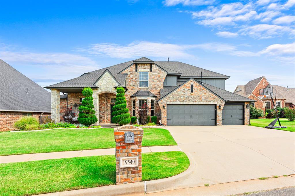 Set in the Thornhill addition in Edmond, this traditional home brings a lot to the table. Manicured spiral topiaries frame the covered entry, and the mix of brick and stone gives the exterior real curb presence, with a three-car garage and generous driveway rounding things out. Step inside and the great room takes center stage, with soaring ceilings, a wall of windows that floods the space with natural light, and a stone fireplace as the focal point. It flows easily into the kitchen, where dark cabinetry, granite countertops, and a striking brick archway with a tiled inset create a warm, gathering-friendly hub. A large island, stainless double ovens, and a combination walk-in pantry and utility room keep things functional, while the adjoining breakfast nook offers a bright spot for morning coffee. A formal dining room off the entry adds a place for more traditional meals or entertaining. The primary suite is a true retreat, with an ensuite bath featuring a soaking tub, separate walk-in shower, and dual vanity. Upstairs, a versatile game room or loft area connects to the spacious secondary bedrooms.Out back, the show stopper is the pool, complete with a natural rock slide, surrounded by a spacious paver patio. A covered outdoor living area with a ceiling fan and built-in space for a TV makes it easy to relax or entertain year-round, all within the sought-after Edmond School District.