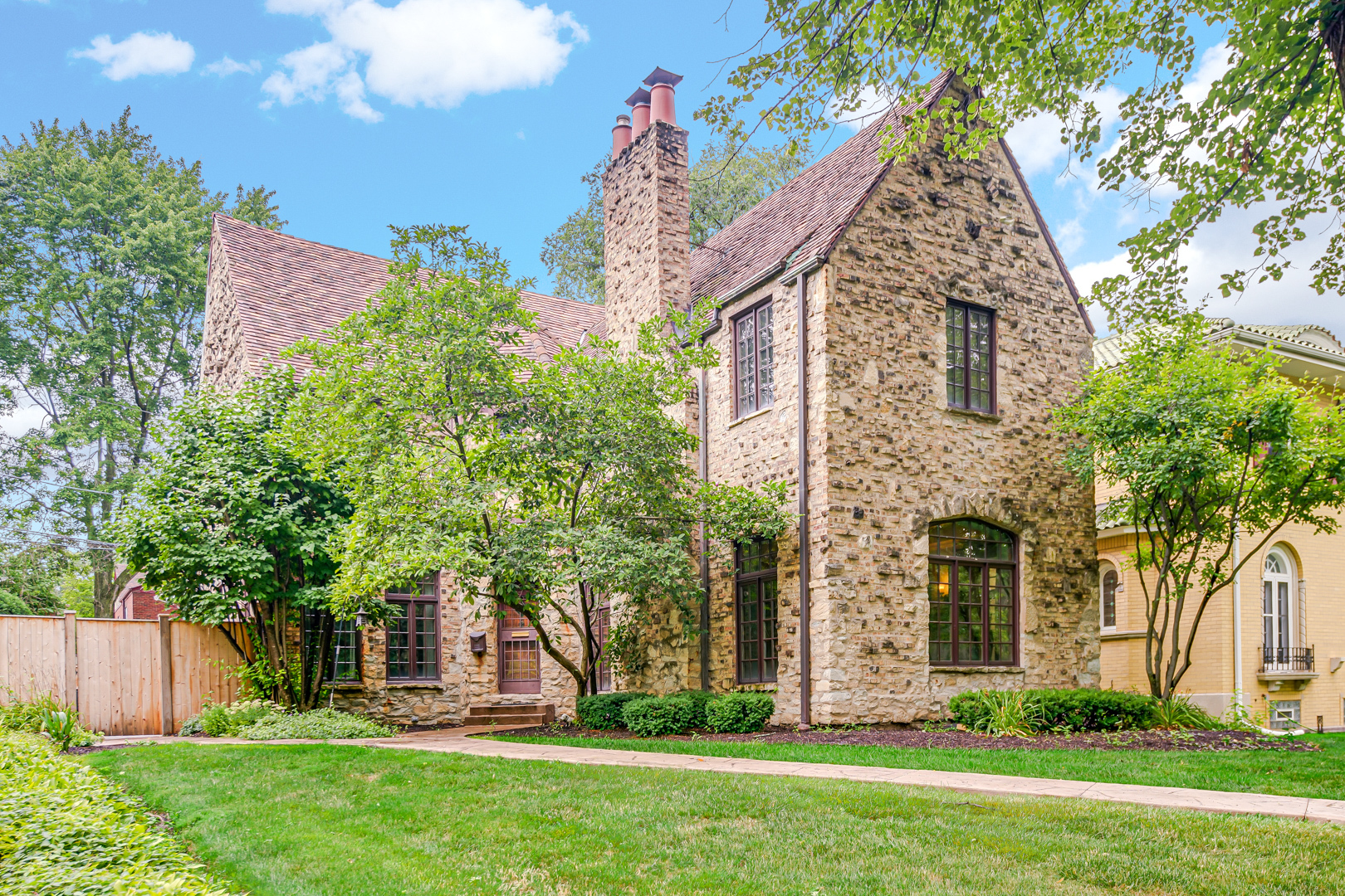 Nestled on Hopkins Place, a charming tree-lined street in the heart of North Beverly, this 1928 Tudor Revival seamlessly blends Historic Charm with Contemporary Luxury. Crafted with a distinctive clinker brick and limestone facade this stately residence exemplifies the character-rich details of the Hetherington Era, while offering fully modernized interiors for today's lifestyle. Inside, the home features 4 spacious bedrooms, each with generous closets, and 3.5 completely remodeled bathrooms, all thoughtfully updated with high-end finishes that complement the home's original design. Features Include: Grand entry foyer with original marble floors, sunken formal living room with gas FP, elegant formal dining room, graceful arched doorways, original iron railings and custom millwork reflecting the craftsmanship of the period, while updates to the kitchen, baths, and major mechanical systems bring effortless functionality. Additionally offering rear driveway with attached heated garage, fenced-in yard, newer Marvin custom casement windows upstairs & down, new copper gutters & downspouts, and a partially finished basement with epoxy floor for additional finished living space. With its storybook exterior, impeccable updates, and a coveted location near schools, parks, and the 91st St Metra, this North Beverly gem is a rare blend of past and present-ready to welcome its next chapter.
