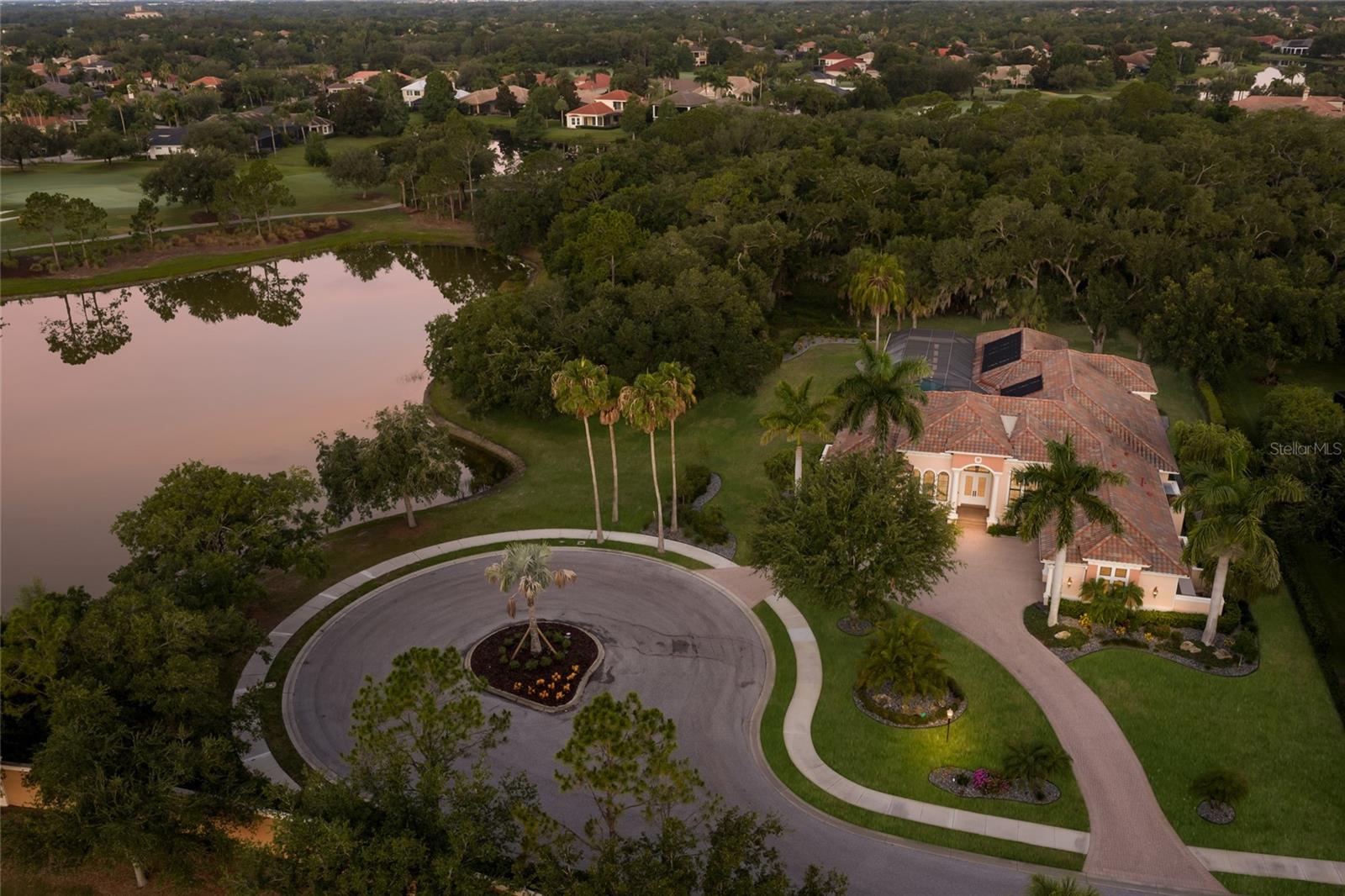 Positioned on .79 acre at the end of its own cul-de-sac with utmost privacy and tranquil water views from this 4,894 square foot ONE STORY offering inside The Lakewood Ranch Country Club boasts preserve to one side, open south-facing lake views to the other, and golf views in the distance.  A trifecta of vistas, this custom built John Cannon Homes residence in the Lacantera enclave showcases impressively largely living spaces, volume ceilings throughout, all generously sized ensuite guest rooms, IMPACT WINDOWS/doors/sliders, GENERATOR, temperature controlled WINE ROOM, and even a CASITA with separate entry. Meanwhile the incredibly-sized 2200+ square foot lanai boasts abundant under cover and open spaces, a large 42’ heated pool and spa, outdoor Summer kitchen and a gas fire pit all seamlessly connected via disappearing impact 10’ Sliders to an invitingly large great room open to the kitchen where form meets function cohesively with sprawling marble counters and backsplash, Albrecht wood cabinetry, high performance appliances including Wolf, Subzero, Miele and Thermador, a secondary prep sink with disposal, reverse osmosis, an oversized hidden walk-in pantry, and large breakfast nook drenched in sweeping views.  Formal living and dining area boast tray and coffered ceilings with double and triple crown moldings, oversized windows and French doors, and a wine room with commercial split cooling system. Additionally, a large club room behind double doors offers built-in wood cabinetry with sink and fridge, walls of windows and disappearing 10’ sliders that all bring the outdoors in.  Rest and relaxation beckons in the elegant owner’s retreat on a private wing offering oversized windows, bamboo flooring, two large walk-in closets, direct lanai access, and a luxuriously appointed spa-like bath with new marble counters and flooring, an invigorating shower, separate vanity stations, oversized soaking tub, and an island an abundance of storage. Family and overnight visitors will be right at home with 2 generously sized guest suites in the main house each with enough room for King size beds, and both with wood flooring, walk-in closets and private full baths. Meanwhile the separate entry casita offers a fourth ensuite bedroom equally as large with a walk-in closet, private full bath and its own breakfast bar with cabinetry, refrigerator and sink.Other notable highlights of this all-encompassing 7,104sf residence includes a private Office with built-ins, a smartly positioned Powder Room, an oversized Laundry Room with sink, cabinetry & outdoor access, two tankless water heaters, three HVAC units, generator, spray foam insulation, solid interior doors, Albrecht cabinetry throughout, landscape lighting, sound system with speakers inside and out, circular driveway, oversized 3 car garage, and so much more. This rare find is a testament to living well in an ideal location within Lakewood Ranch known for its vibrant lifestyle near dining, shopping, polo, golf, tennis, events and entertainment near Waterside, Centerpointe, UTC area, and of course, in an A-rated school district next to ODA and a few miles from IMG.