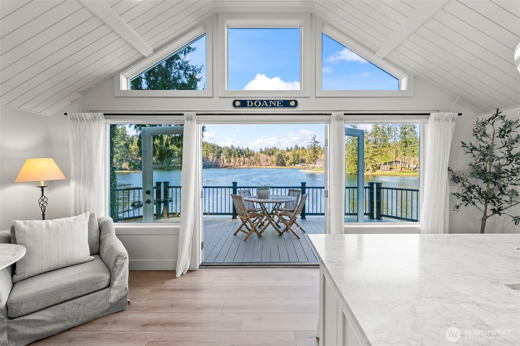 Set along one of Gig Harbor’s most coveted bays, this Nantucket-inspired beach cottage is a true coastal gem. With 104 feet of low-bank waterfront on Wollochet Bay, it offers the perfect everyday retreat. Thoughtfully remodeled and re-envisioned from the inside out, the home lives like new while preserving its coastal character. Wrapped in hand-dipped cedar shakes, it feels like a seaside escape from the moment you arrive. Inside, vaulted shiplap ceilings and abundant natural light create an airy, inviting atmosphere, while quality craftsmanship and timeless finishes shine throughout. French doors open to a generous wraparound deck, perfect for relaxed mornings and stunning sunrises. Enjoy a dreamy kitchen complete with marble countertops, a farmhouse sink, paneled appliances, and a Dutch door that welcomes in the coastal breeze. A loft with sweeping water views offers a cozy space for a second bed or family room. Downstairs, the daylight basement hosts a serene primary suite with a spa-like bath featuring walnut cabinetry, marble finishes and a spacious walk-in shower. Ideal for kayaking, bird watching, and summer swims—where salt air and gentle tides set the rhythm of daily life.