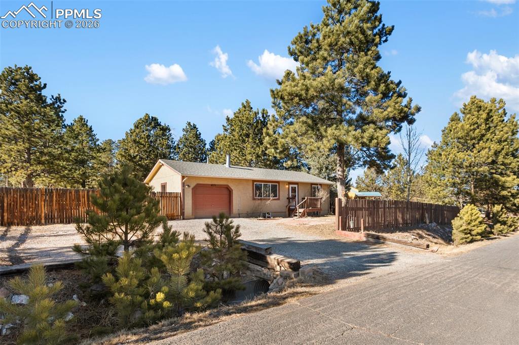 Welcome to this inviting mountain retreat in the heart of Woodland Park, where towering pines, fresh Colorado air, and a spacious, level lot create an ideal setting for relaxed mountain living. This ranch-style home offers a practical, easy-flow layout that connects the living area to a functional kitchen featuring stainless steel appliances, ample counter space, and a convenient pass-through bar—perfect for everyday living and casual gatherings. Recent updates include newly remodeled basement bathroom, new LVP flooring and trim throughout the entire home, adding a clean, modern feel while maintaining warmth and durability. The bedrooms are filled with natural light and provide comfortable retreats and newly installed LVP flooring and closet doors. Downstairs, the basement expands your options with laundry, an additional bathroom, and flexible space well-suited for storage, hobbies, a workshop, or future living area potential. Step outside to enjoy a large, fenced, wooded, and level yard, ideal for pets, play, or simply soaking in the peaceful surroundings. A covered patio extends outdoor living through multiple seasons, while a storage shed keeps tools and gear neatly organized. With plenty of parking and a roof replaced in 2021, this home offers both convenience and peace of mind. Ideally located with easy access to hiking and biking trails, Pikes Peak recreation, and Woodland Park’s shops, dining, and amenities, this property supports a lifestyle rooted in the outdoors while staying connected to town. A versatile mountain home with room to grow—discover the possibilities this Woodland Park retreat has to offer.