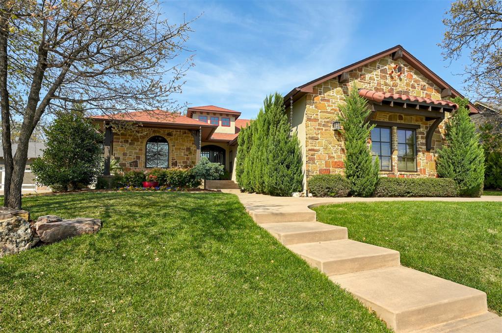 Welcome to this award-winning Parade home in the sought-after Edmond community of Town Square. Ideally positioned across from the lake and scenic walking trails, this home offers an exceptional location with timeless design, modern comforts, and thoughtful upgrades throughout. From the moment you arrive, the inviting curb appeal sets the tone—lush garden beds bursting with color frame the spacious front porch, creating a picturesque welcome to this Spanish-style home. A terracotta colored roof, stucco and stone facade, oversized copper-like gutters with rain chains, and stunning iron double-hung doors set the scene. Inside, the home has a Tuscan feel with soaring ceilings and abundant natural light enhancing the open layout. Earth tones anchor the space from the cabinetry to the hand-scraped wood floors. The living room impresses with dark wood beams, vaulted ceilings and a gas fireplace, offering both sophistication and warmth. The chef’s kitchen is as functional as it is beautiful, featuring double islands, a walk-in pantry, and a built-in china cabinet in the breakfast nook with arched wood shutters and rich wainscoting. The serene primary retreat includes a spa-like bath with a soaking tub, walk-in shower, dual vanities, private toilet closet, and a large walk-in closet. Two secondary bedrooms share a Jack-and-Jill bath with a double vanity and tiled tub/shower. A home office with built-ins and a desk offers flexibility and can double as a guest retreat with a nearby half bath and closet. Enjoy the spacious Florida room with sliding glass doors and screens—perfect for morning coffee or evenings with friends. The backyard features mature trees for privacy and space to entertain. Just a short walk away, the Residence Club offers fitness equipment, a studio, indoor and outdoor kitchens, an infinity pool, and a playground.