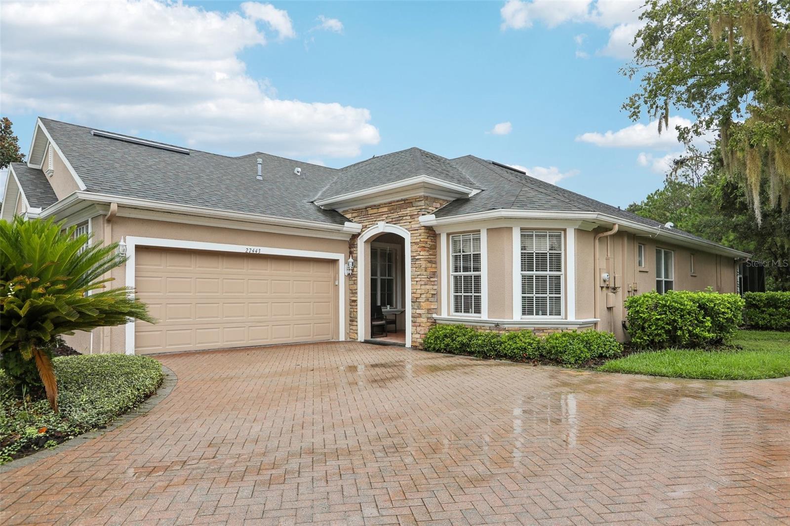 Welcome to this exceptional and rare villa in the prestigious Seven Oaks community! One of only two pool homes in this gated and quiet sub-neighborhood, you are truly in for a unique opportunity that you will surely make your FOREVER home! From the moment you enter, enjoy a stunning view through the spacious great room and triple sliding glass doors to a calming view of  screened lanai, pool and spa, tropical foliage, and beyond to a lush conservation area and pond. Rich engineered hardwood flooring enhances the open living areas, with an inviting space for everyday living or entertaining. The expansive primary suite features a tray ceiling, with ensuite bath featuring relaxing jacuzzi tub,  glass-enclosed shower, dual marble vanities, private water closet, oversized walk-in closet. The light-filled second bedroom offers French door access to the pool. The 3rd  bedroom is separated from the 2nd by a full bath with double sinks and also features a double size closet with bi-fold doors. A separate den near the entry makes an ideal home office or library that can be closed off with French doors for added privacy. This well-appointed kitchen features 42-inch solid wood cabinetry, marble countertops, a generous chef's island, stainless steel Bosch and Whirlpool Gold appliances, 6 burner gas range, a spacious pantry, and a convenient eat-in nook. Additional highlights include a laundry room with built-in closet & cabinetry, newer washer and dryer, and a utility sink; and an oversized two-car garage with newly installed rubber flooring with surrounding shelving. Tucked away on a quiet cul-de-sac, this villa offers exceptional privacy and peaceful views. CDD and LOW HOA fees provide enjoyment of all the  Seven Oaks' outstanding resort-style amenities, including a clubhouse and café, five tennis courts, pickleball, basketball, Junior Olympic pool, lap pool, an additional swimming pool, children's water park and playground, fitness center, aerobics room, movie room, and gathering spaces. Enjoy the perfect combination of private poolside living and an exceptional Wesley Chapel lifestyle that checks all the boxes! Only 5 minutes to restaurants and shopping at shoppes of Wiregrass!