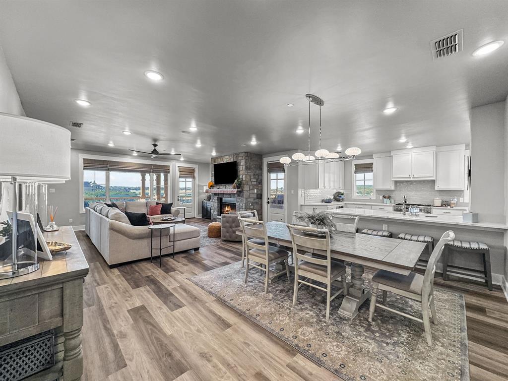 Built in 2021, this stunning fully furnished condo is located within the amenity-rich The Harbor at Possum Kingdom community and showcases a sleek modern-contemporary design throughout. Thoughtfully designed with an open-concept layout, the living, kitchen, and dining spaces seamlessly flow together creating the perfect setting for entertaining or relaxing at the lake.Enjoy breathtaking lake views from the expansive wraparound patio, offering scenic water views in every direction. This turnkey residence features 3 spacious bedrooms, 3 full baths, plus a half bath, providing ample space for family and guests alike.Additional highlights include an assigned garage space and covered carport parking for added convenience. Located just a short walk from the resort-style pool, fitness center, marina, dining, and upscale community amenities, this lock-and-leave lake retreat offers the ideal blend of luxury, comfort, and convenience at Possum Kingdom Lake.