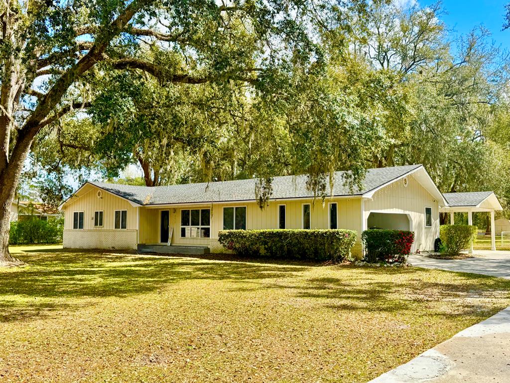 Spacious and beautifully renovated 4-bedroom, 3-bath ranch-style home situated on a manicured 3.75-acre lot. This move-in-ready property has been completely updated from top to bottom, featuring a stunning kitchen with brand-new appliances, elegant marble countertops, and modern recessed lighting. The bathrooms have been fully renovated with stylish glass doors and luxury vinyl flooring throughout the home.  The extra-large primary suite offers generous walk-in closets and a private en-suite bathroom for added comfort and privacy. Additional highlights include a spacious two-car garage, plus an additional two-car carport for extra parking or storage.  Enjoy outdoor living and entertaining on the back deck overlooking the expansive property. A wooden storage shed provides additional space for tools or equipment.  Major upgrades include new plumbing and a new air conditioning system for peace of mind. The home is serviced by a two private well and sits on a beautifully maintained 2.11-acre lot, offering both space and privacy.
