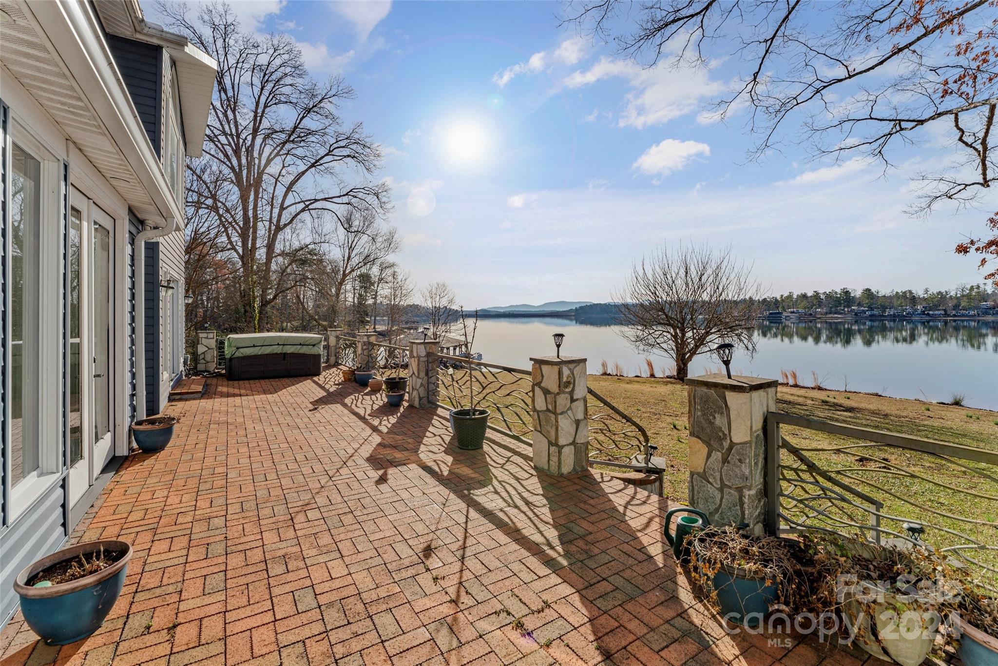 Discover lakeside living in this stunning waterfront property. Nestled on a private one-acre level lot, this home offers breathtaking long-range views & unforgettable sunsrises over Lake James. Featuring 3 spacious bedrooms & 3.5 bathrooms, including 2 primary suites, catering to both comfort & privacy. With over 3800sf, there is ample space for relaxation and entertainment. The interior boasts hardwood floors throughout. The billiard room, bar area and expansive brick patio overlooking the lake offer perfect settings for gatherings of all sizes. Outdoor enthusiasts will delight in the property's direct waterfront access, PRIVATE boat ramp and covered dock with large seating area. The solar panels ensure energy efficiency without compromising on comfort. The property includes a generous 3-car garage & 2-car covered parking, accommodating cars, RVs and watercraft alike. No HOA and short-term rentals are allowed.  Enjoy your solitude on the quiet location just off the main channel.