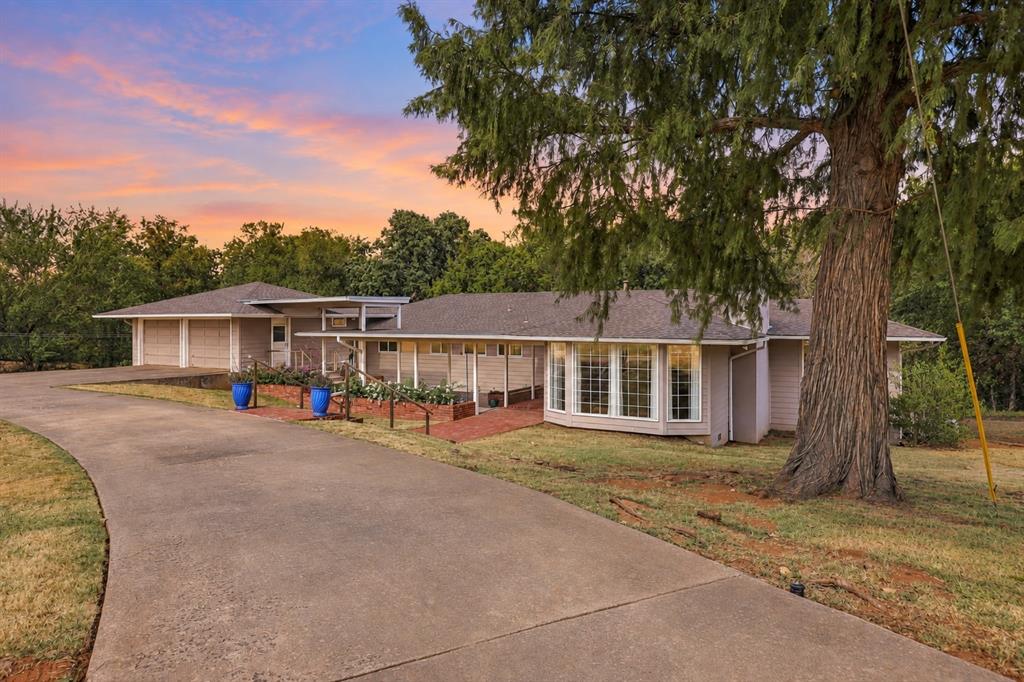 OPEN HOUSE SUNDAY 9/20 FROM 2-4 PM. A striking contemporary retreat in Forest Park unlike anything else on the market, backing to a peaceful creek framed by mature trees, creating a private, wooded backdrop on just under 1.5 acres that feels remarkably removed from the city. From the circle drive, an oversized front porch and garden area welcome you into a home designed for gathering. Inside, multiple living spaces are surrounded by walls of windows, filling the home with natural light and framing the wooded landscape beyond. The front living room features a bay window and fireplace, while the den boasts space to spread out and an impressive sound system perfect for movie nights. The oversized kitchen was built for entertaining with abundant countertops and cabinetry, stainless steel appliances like a gas range and double oven, two bars w/seating areas, two sinks, walk-in pantry, and pass-through windows connecting directly to the back patio for seamless indoor-outdoor hosting. The sunken library lounge is a true architectural moment, anchored by a dramatic glass corner that creates an incredible connection to the surrounding landscape. The primary ensuite is a serene retreat, featuring a generous walk-in closet with custom built-in storage and a spa-inspired bathroom complete with a statement claw-foot soaking tub and spacious walk-in shower. A walk-out basement adds flexible living space with two bedrooms and a bathroom downstairs. Enjoy mornings on the front porch, dinner and drinks on the refinished deck, or a match on your private tennis/basketball court. A two-car garage with additional storage underneath adds even more functionality. Located approximately one mile from Twin Hills Golf & Country Club, less than 15 minutes from Downtown OKC, and ideally positioned along the I-35 corridor for convenient access throughout the metro. This is a home you simply must experience in person. Inquire for the full features list and schedule your private showing today.