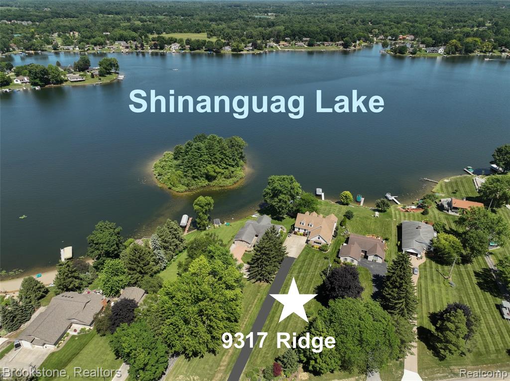 Enjoy lakefront living at its finest on the shores of Private All Sports Shinanguag Lake in gorgeous Goodrich – just 12 miles north on M-15 from Clarkston! Nestled on a premium lot of over two-thirds of an acre, this stunning home offers breathtaking water views and 72 feet of shore line including a private beach area for kayaks and sand castle building! The home was expanded in 2007, taking it to the next level of style and functionality. The great room, casual dining and kitchen are open concept and perfect for entertaining. The kitchen has upgrades such as granite counters, a central island, and a walk in pantry. The service entry can house laundry once again, if desired. The great room includes a cozy gas fireplace and provides stunning lake views. The casual dining leads to a covered balcony where you can take the dining outside. The entry level primary suite is sunny and bright, and features a private balcony overlooking the lake, a generous 5’x10’ walk-in closet, and an elegant en suite with walk in shower. Bonus guest room on entry level is perfect for those who prefer not to climb stairs. The 9 foot ceiling height can be felt in the amount of natural light this home enjoys!  The second floor expansion includes 3 huge bedrooms and a full bath. The finished walk out lower level continues to expand your living and entertaining space with a second gas fireplace, a full wet bar with a bar fridge, a sixth bedroom, full bath and direct access to the beautifully landscaped yard. There is also a double door that leads to back patio from a 35’x11’ storage area which provides ample room for lake gear, hobbies, and more. The garage is an impressive 27 feet deep! Your dream of lake front living with space for family and friends to visit with you is about to come true!!