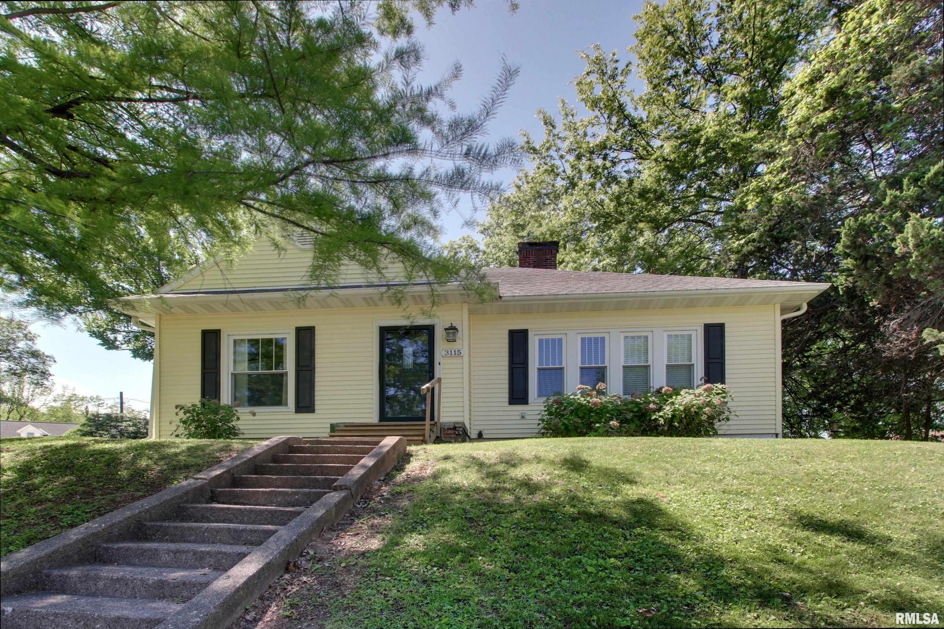 Welcome home to this darling cottage where vintage charm meets thoughtful modern updates. From the moment you arrive, you’ll be captivated by the inviting curb appeal, lush landscaping, and low-maintenance vinyl siding paired with 6” gutters and gutter guards for true peace of mind. Step inside to discover 1,388 square feet of warm, light-filled living space showcasing gorgeous original hardwood floors throughout the dining and living areas, and bonus: there’s hardwood hiding under the carpet in both bedrooms, just waiting to be revealed!   The spacious 14x23 living room is anchored by a stunning fireplace, perfect for cozy evenings and gatherings with loved ones. Replacement windows flood every room with beautiful natural light. The kitchen comes fully equipped with all appliances  making your move-in seamless. The adjacent dining room features rich hardwood floors that flow naturally throughout the main living spaces and a generous main floor laundry room (washer and dryer included!) adds everyday convenience.   You’ll love the updated bathroom featuring a vintage-look tile design that perfectly complements the home’s classic character. Two comfortable bedrooms offer peaceful retreats and downstairs the unfinished poured walk-up basement provides a massive 1,262 square feet of potential, ideal for storage or workshop space. Outside the large lot truly shines with alley access, a detached 1-car garage, and an additional off-street parking slab for 2-3 more vehicles.
