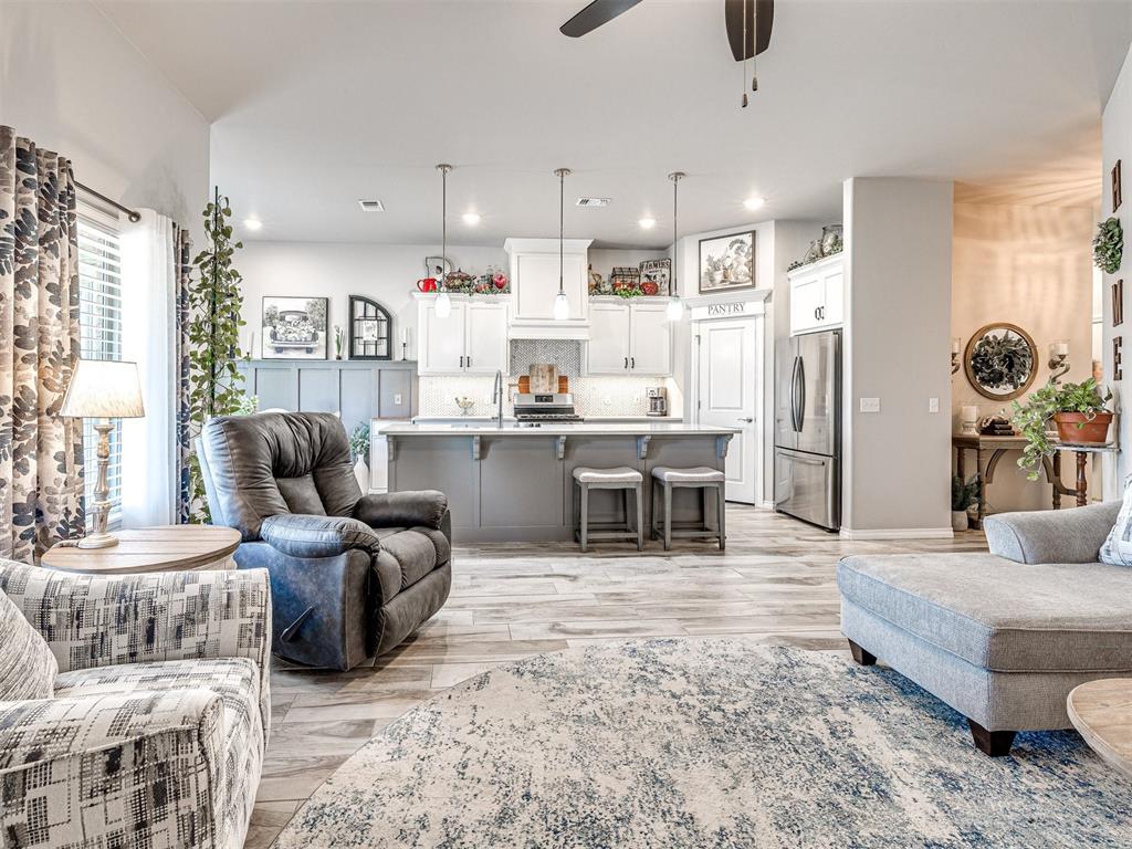 This elegant, energy-efficient home offers an ideal blend of comfort, craftsmanship, and convenience. The beautifully landscaped yard sets the tone for what you’ll find inside: a thoughtfully designed interior filled with upscale finishes and smart features. Wood-look tile runs throughout the main living areas, enhancing both style and practicality. The open-concept living area centers around a gorgeous stone-stacked fireplace and flows seamlessly into the chef’s kitchen.
Equipped with custom 36” cabinets extending to the ceiling, a stainless steel farm sink, under-cabinet lighting, and a generous island with bar seating, the kitchen is as functional as it is attractive. A dedicated pantry adds convenience, while the adjacent living space makes it ideal for hosting or relaxing.
The primary suite features a spa-like en-suite bath complete with a jetted tub, European walk-in shower, and separate vanities. Practical home upgrades include a built-in storm shelter in the garage, tankless water heater, energy-efficient double-glazed low-e windows, and a fresh air intake ventilation system. Outdoors, enjoy a covered patio with a wood-burning fireplace, gas hookup, and cable outlet. The fully fenced yard includes smart irrigation and sprinkler systems in both the front and back. Neighborhood amenities include a pool, park, and basketball courts.
