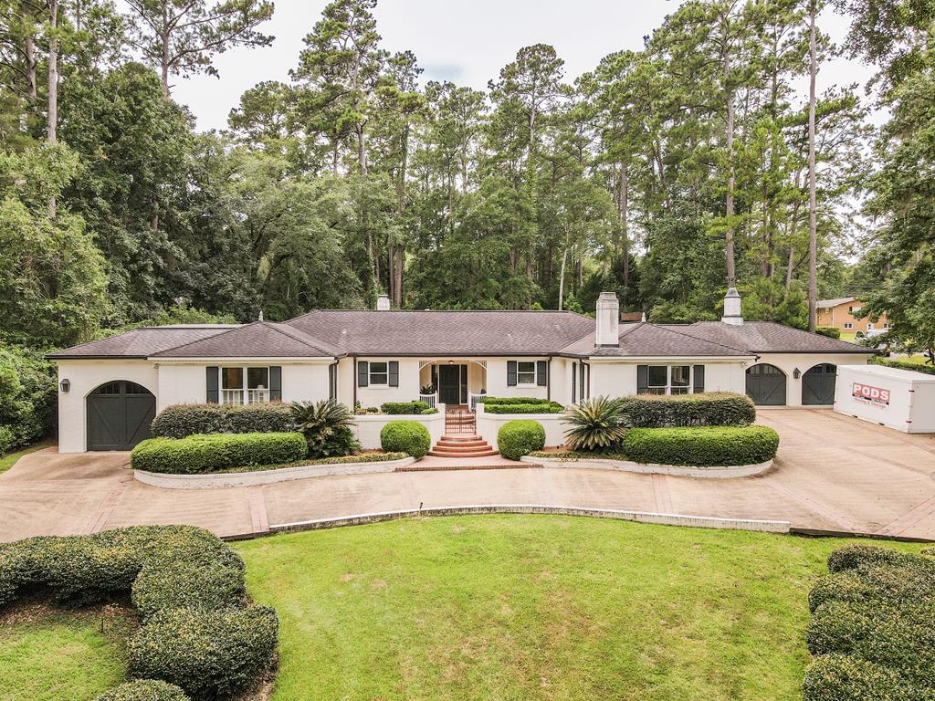Classic one-story home rich with details now available in Thomasville. Welcome to 104 Camellia Drive across the street from Glen Arven Country Club and moments from Archbold Medical Center. This southern style brick home has 4 bedrooms & 3.5 bathrooms in approximately 4,519 sf plus approximately 360 sf bonus heated & cooled space in attached/detached garage. Main spaces include large light filled kitchen with keeping room and wood burning fireplace, formal dining with glass door access to the patio as well large storage closets for linens and china, study with built-in bookcases and paneled walls, family room with wood burning fireplace, coffered ceiling details and French door access to the patio and a large powder room just off of the main foyer. Goutmet kitchen features a large wooden island with skylight, gas cooking, stainless appliances and large walk-in pantry with enough room for a chest freezer.   The oversized laundry room has a built-in desk and plenty of room for additional storage. The large master suite has a beautifully updated bathroom with double sink vanity, tile shower and garden tub and separate toilet closet plus large walk-in closet.  Two bedrooms have a shared bonus space for TV, studying or a playroom and share a Jack & Jill style shared bathroom with double sinks and a separate space for the tub & toilet. The 4th bedroom has access to a hall bathroom. Both bonus garages are each served by separate heating a cooling units making them self-sustaining when not in use. Outfitted with gorgeous wood paneling and marble tile in the floor as well as built in bookcases, these spaces can be used for office, game room,  hobby workshop, car storage or climate controlled storage. The bonus garages are in addition to 2 attached garages that are off of the back door by the kitchen entrance.  The large well landscaped 1.16 acre yard features a beautiful exposed aggregate concrete circle driveway with brick border and accents. The backyard features a large brick patio off of the dining room and living room with a flagstone path leading to the gunite swimming pool. Plus there is a large storage building at the rear of the property for garden and yard storage.