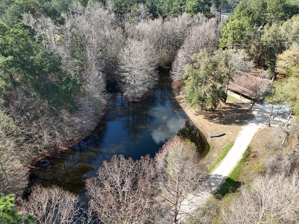 Step into your own private frontier at 415 Jane's Lane in Ochlocknee GA! This rustic 3BR/2Bath home sits on 12 sprawling acres, features a meandering gated driveway, and has all the fish you can catch in your own private pond, right outside the front door. Inside you will find huge open living space, all accented by gorgeous knotty pine interiors and exposed brick. The living room flows nicely into a well-appointed kitchen equipped with the latest appliances, and nice dining area. Big French doors offer amazing views of the property, and lead right out onto the wonderful front porch. Home was built in 2009 beyond traditional construction code to withstand severe storms. Recent additions include new flooring, new carpet in bedrooms, new kitchen cabinets including the island, new countertops, new flagstone on the front porch and new metal roofing over the porch. The primary suite is massive, and features its own bathroom and walk-in closet. Two other bedrooms at the back of the house share another full bath. Aside from the shady and scenic pond, the property also features beautiful stands of pine and oak trees, and 8 acres recently planted in pecan trees and irrigated. Pecan varieties include Oconee and Avalon, which is a fairly recent variety developed by the University of Georgia, and Elliot varieties for pollination. All this in a great private community along Jane's Lane. Call your favorite agent TODAY for a closer look at this amazing property. Click here for a virtual tour: https://my.matterport.com/show/?m=nVZCgH7yN3E&mls=1