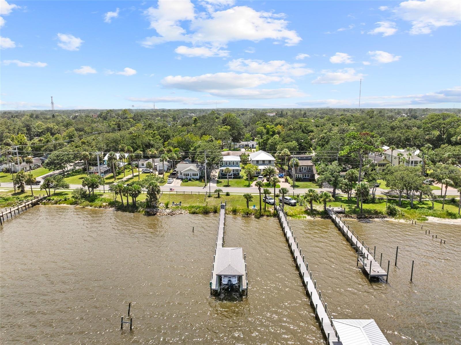CALLING ALL BOATERS!!Step into your dream lifestyle at this stunning custom-built intracoastal home. Completed in 2020, this elevated Miami-Dade hurricane-code home blends timeless charm with top-tier construction — perched on a crawlspace in a non-flood zone for added peace of mind. Enjoy riparian rights, your private covered boat dock with electric, water, and an 8,000-lb boat lift, and incredible panoramic views from your 30’ x 8’ east-facing front porch complete with ceiling fans — perfect for lazy mornings and peaceful evenings. Inside, a bright open floor plan boasts 10-foot ceilings, engineered hardwood floors, and an open-concept living space centered around a chef’s kitchen with an oversized granite island, custom cabinetry, and top-of-the-line stainless GE Café appliances, including a gas stove with hood, double oven, and large walk-in pantry. The main-level primary suite opens to a private porch, with a luxurious ensuite bath and walk-in closet featuring custom built closet systems. Upstairs offers two guest bedrooms, a full bath, and an impressive second living/flex space with sweeping river views, custom blinds, and ceiling fans throughout.Additional features include hurricane-impact windows & doors, detached 2-car garage, Hardie board siding & metal roof, Trex decking on front & rear porches, AO Smith gas tankless water heater, twin Trane XR HVAC units, full-size stackable Electrolux washer/dryer, covered rear porch + paver patio, and plenty of room for a pool on nearly ¼ acre. Launch right from your dock and enjoy direct access to deep-sea fishing at Ponce Inlet, just 6 miles south. Only 5 miles to Daytona Speedway, 6 miles to LPGA International Golf Club, Florida Tennis Center across the street, Pictona world-class pickleball facility 1 mile away, and Ormond Beach restaurants and shopping just minutes up the road. This home is turnkey coastal perfection—built strong, designed beautifully, and ideally located. Don’t miss your opportunity to own your own slice of paradise!