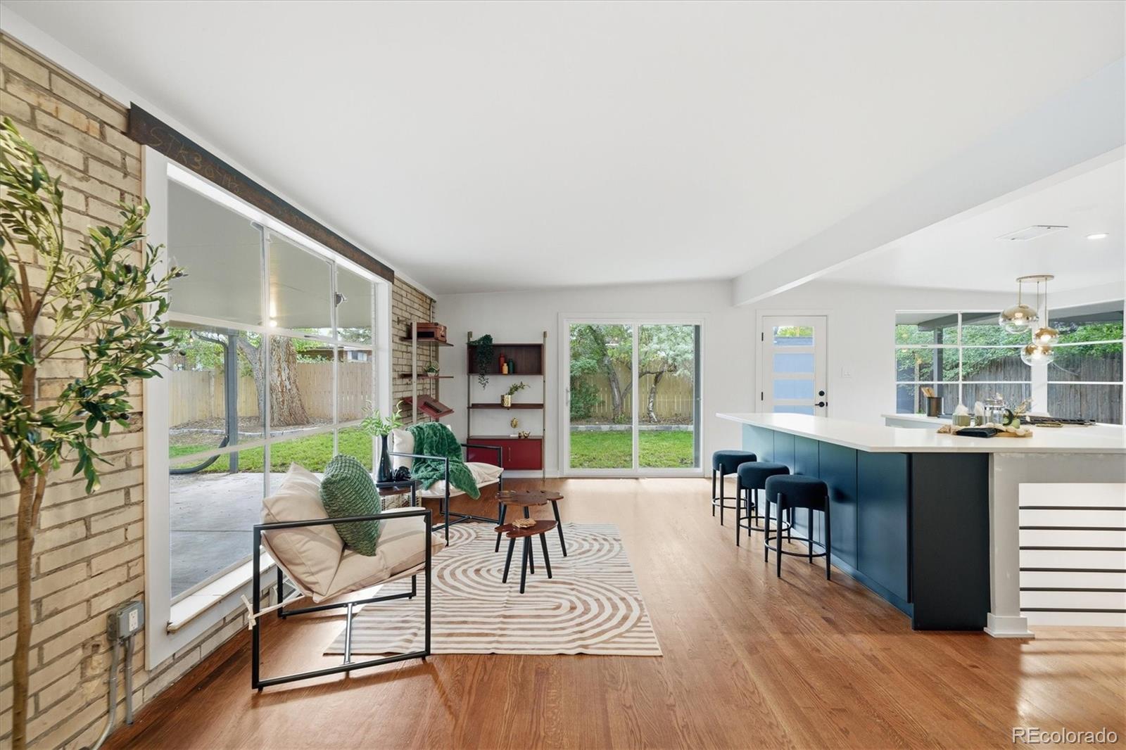 Move-in ready mid-century modern in Lakewood with incredible natural light, a finished basement, rare drive-through garage and indoor-outdoor spaces that make the home live larger than expected. Remodeled in 2019, the home features an open kitchen with gas range, pantry storage, dedicated dining space and a large island with additional seating and storage. Hardwood floors, oversized windows and an exposed brick accent wall bring warmth and personality to the upstairs living space, while the easy flow between the kitchen, living room and backyard makes hosting friends, keeping an eye on kids or simply enjoying everyday life feel effortless.The spacious primary suite includes a walk-in closet, dual vanities, soaking tub and oversized shower w/ bench seating. An additional upstairs bedroom and full bathroom provide flexibility for guests, office space or changing needs over time. Downstairs, the finished basement adds even more usable living space with a large den/family room, non-conforming bedroom, bathroom, additional office or gym space and a second kitchenette added in 2019. Whether you need room for guests, hobbies, work-from-home life or extra separation between living spaces, this lower level gives you options. Outside, enjoy a covered patio, mature shade tree, irrigated front and back yards, storage shed and covered walkway connecting the home and garage. The detached 2-car garage features drive-through access with garage doors on both sides, creating additional flexibility for parking, projects, storage or easy backyard access. Driveway and street parking are also available. Notable home improvements include: modern doors, hardware and lighting, radon mitigation system, sewer line improvements with clean-outs and all appliances included, including washer and dryer. Conveniently located near parks, shopping, dining and commuter routes, this home offers a hard-to-find combination of character, usable space and move-in-ready comfort at this price.