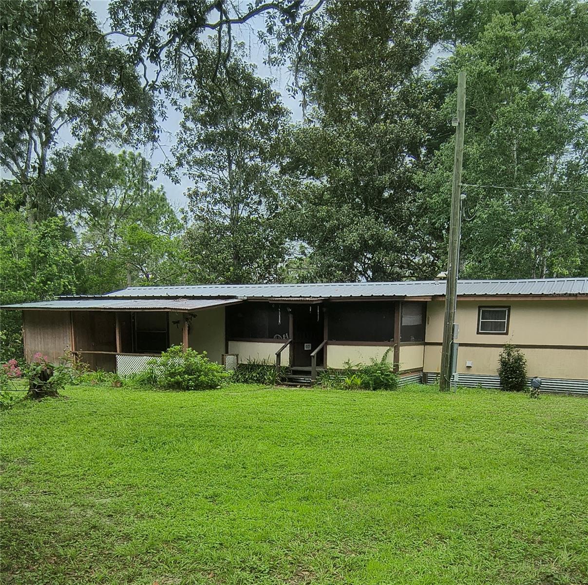If your heartstrings are calling you to start your own mini farm or homesteading take a look at this. This is a beautiful 2.5 acres of flat beautiful piece of  land fenced in with two homes on it. The trees are incredible hundreds of years old. Both mobiles are in pretty good condition. They both sit off the road mid way on the lot which is 154 wide and 660 deep. One is a 1 bed 1 bath with a large screened porch. Perfect for a rental of family or friend. The main homestead has a large porch on the front and back 2 bed 2 bath. Deals like this don't come along that often! Call today to see!