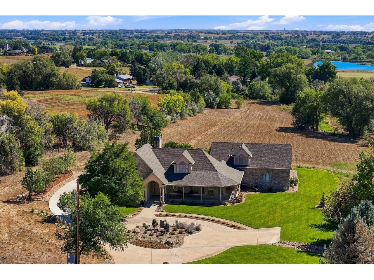 A Distinctive Colorado Country Estate with Exceptional Acreage, Views & Amenities. Privately set on nearly 13 acres just off Highway 287, this exceptional Colorado country estate offers refined living, expansive space, sweeping foothill views, and remarkable agricultural potential. Formerly cultivated in alfalfa, the acreage offers opportunities for livestock, equestrian pursuits, agriculture, and other permitted uses. The elegant all-brick residence features a gracious wraparound porch, beautifully landscaped grounds, and an east-facing deck. Inside, the dramatic great room showcases refinished hardwood floors, a brick gas fireplace, crown molding, sculpted ceilings, and abundant natural light through Pella windows. The spacious kitchen offers abundant oak cabinetry, generous counter space, a breakfast bar, and casual dining nook. The main level includes a luxurious primary suite with five-piece ensuite and oversized organized walk-in closet, a second bedroom, private office with built-ins, hobby room, powder room, laundry, and direct access to the three-car garage. Upstairs are a spacious recreation room, two additional bedrooms, and a full bath. A substantial unfinished basement provides excellent potential for additional living or recreation space and includes two furnaces, two A/C systems, fire suppression, and fireplace rough-in. Outside, a 4,000-plus-square-foot Morton barn with steel siding and roof provides exceptional space for equipment, storage, agricultural operations, or workshop use. Three early-1900s structures, including the original farmhouse, add to historic character. A permitted well and A, B & C Shares of White Rock Ditch water further enhance the property's agricultural appeal. Conveniently located near Alexander Dawson School, with easy access to Boulder, Lafayette, & Longmont.