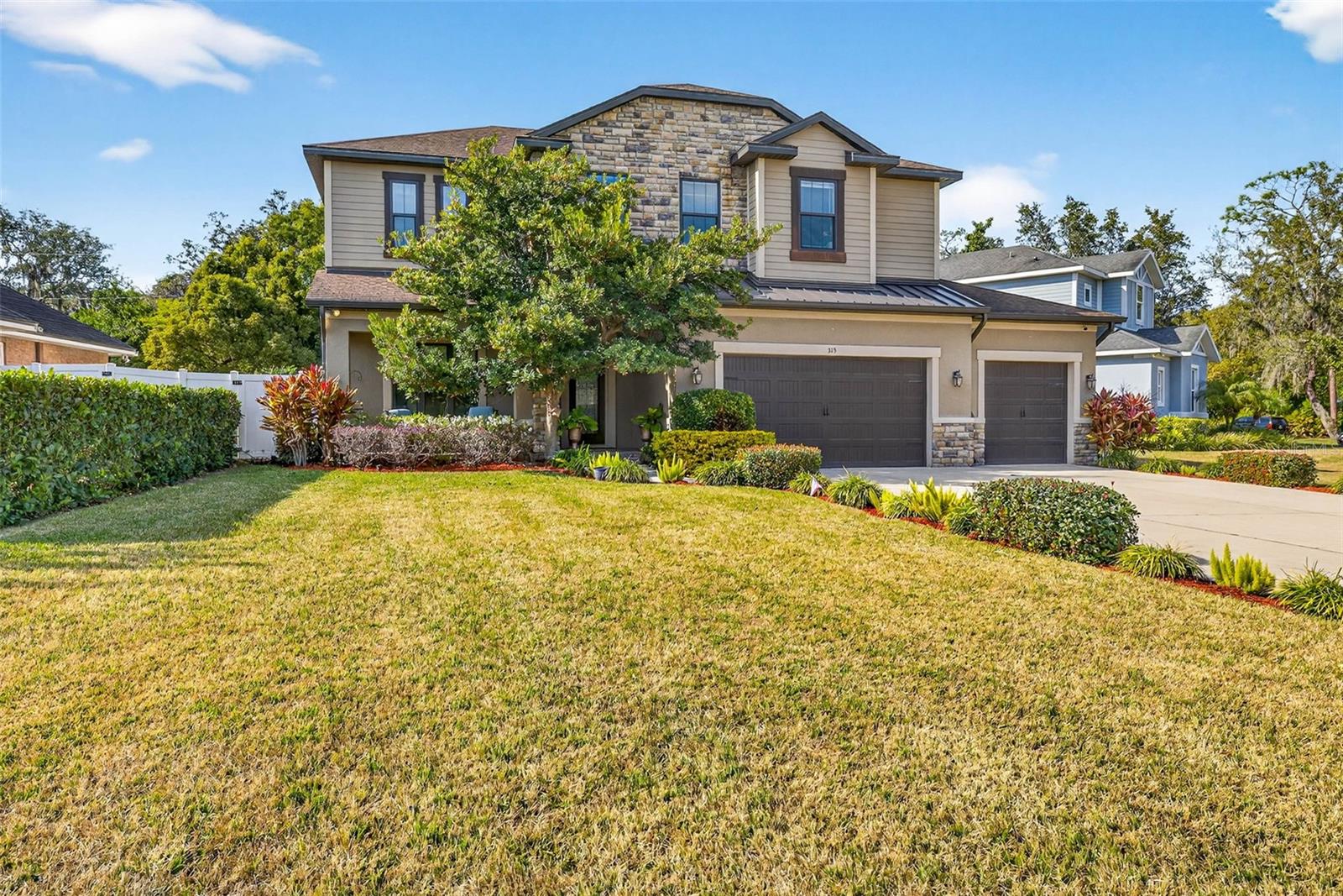 Welcome to this beautiful, energy-efficient five-bedroom, 3.5-bath home perfectly positioned with views of the 7th fairway of the Temple Terrace Golf & Country Club. The exterior showcases durable Hardie® board siding complemented by a custom cultured stone façade and decorative metal roof, offering both timeless curb appeal and low-maintenance living.Inside, the thoughtfully designed first floor features a private home office and a spacious primary suite highlighted by tray ceilings and high-end finishes. The main living area includes a formal dining room, indoor laundry, a convenient half bath, and an expansive chef’s kitchen that opens seamlessly to the family room with striking custom wood beams.The kitchen is designed for both everyday living and entertaining, offering high-end stainless steel appliances, a gas range, GE Café refrigerator, floor-to-ceiling pantry, oversized granite island, and a generous eat-in space overlooking the backyard.Double French doors lead to the covered back patio, where you can relax and enjoy a lush tropical garden. The landscape features an impressive variety of plants and fruit trees, including pink tabebuia, azaleas, gardenias, Concord grape and passionfruit vines, blackberries, Barbados cherry, avocado, dragon fruit, papaya, banana, and strawberry guava.Interior upgrades include a new whole house water softener and filtration system spray-foam insulation, double-pane energy-efficient windows, tankless gas water heaters, solid wood cabinetry, granite countertops, 5-inch baseboards, custom wood beams, and French doors with built-in blinds. Porcelain flooring throughout the first floor adds durability and style.Additional exterior features include pavered front and back porches, dual-zone HVAC systems, a seven-zone irrigation system with a separate irrigation meter, and unmatched views of the historic Temple Terrace Golf Course’s 7th fairway.Residents benefit from the Temple Terrace Recreation Center (The "Rec") which offers several pools, basketball courts, tennis & pickleball courts as well as many classes for all ages.  The Temple Terrace Golf Club is also nearby providing options for golfers as well as other membership opportunities. A complimentary 3 month social membership is available to new buyers.