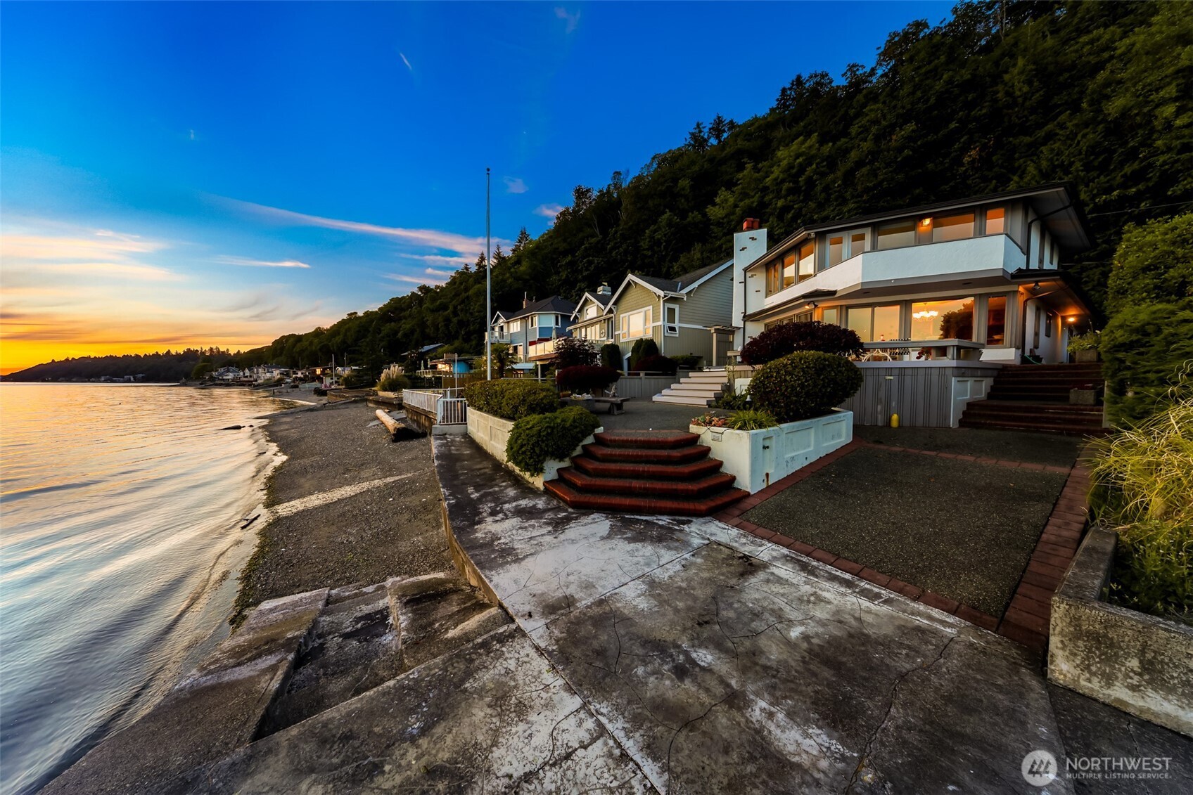Discover this rare private waterfront gem on Standring Lane in Burien’s exclusive gated community. Boasting 41 feet of low-bank Puget Sound frontage, this custom home by famed NW architect Milton Stricker—inspired by his work with Frank Lloyd Wright—features dramatic angles that accentuate water views from every room. This home offers expansive westerly sunset views of Vashon Island and the Olympic Mountains. Enjoy true beach ownership with tideland rights, solid bulkhead, boat ramp & steps to water—plus private buoy & moorage privileges as property lines extend to mean low tide. A newer Azek deck provides generous outdoor living space with an Onsen saltwater hot tub and ample storage below for a boat, kayaks, crab pots, and more. Relax to the soothing sounds of the waves while watching sea life such as whales, seals, and waterfowl. The main level offers an open kitchen flowing into dining and living areas—all overlooking the Sound—plus a convenient guest bathroom. Upstairs, the primary suite includes an ensuite bath and private balcony above the water, complemented by a second bedroom, ¾ bath, and convenient laundry area with sink. Additional highlights include a large 2 car attached garage with EV outlets that doubles as workshop space and three uncovered parking spaces—rare convenience for waterfront living. This unique, view-oriented floor plan on one of Burien’s most desirable waterfront streets presents an outstanding opportunity to create your dream Sound-side home.