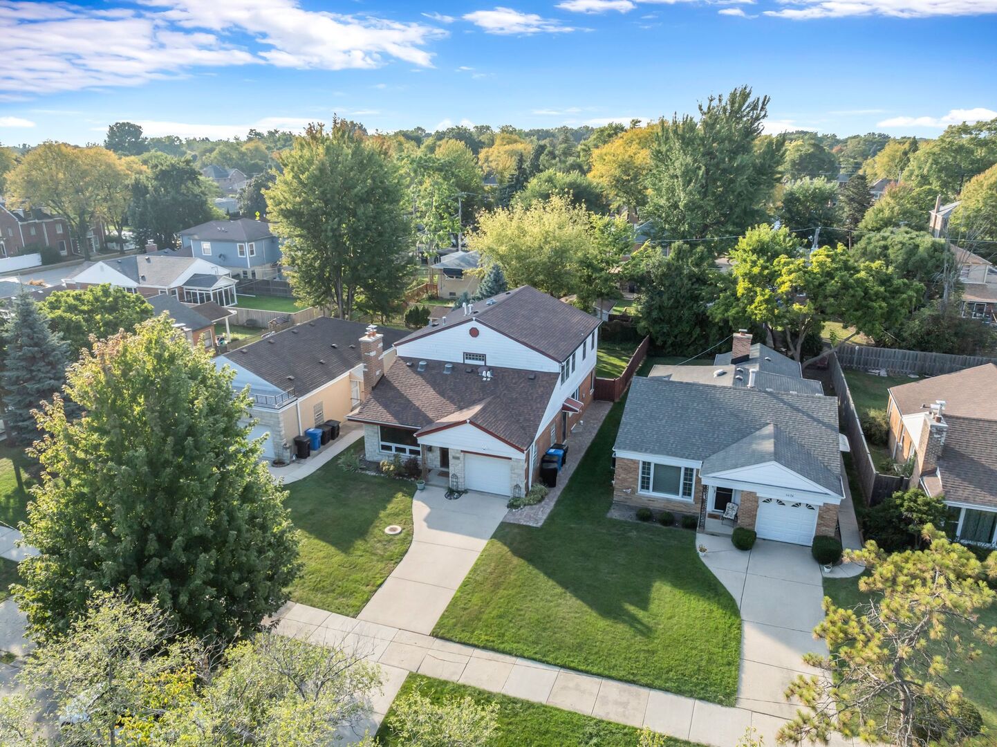Discover this rare 5-bedroom, 3-bath panelized-style gem in the heart of highly desirable Edgebrook, beautifully maintained and thoughtfully upgraded by its long-term owner! Step inside to a spacious main level featuring a welcoming living room with a cozy brick fireplace, a formal dining room, and a chef's kitchen boasting high-end stainless steel appliances, Silestone countertops, 42" custom cabinetry, and designer backsplash. Two versatile bedrooms with a full bath on the main floor offer the perfect setup for in-laws, guests, or a private home office, while the sun-filled four-season room invites you to relax and enjoy serene evenings. Upstairs, you will find three generous bedrooms and a full bath with convenient laundry. The fully finished basement is designed for entertainment with a wet bar, cedar closet, abundant storage, a second laundry room, and a spa-like full bath with steam shower. Recent updates include a newer roof and gutters (2019), custom blinds, chimney liner (2022), brick replacement and tuckpointing (2023), dual-zone comfort with two furnaces and ACs (upper HVAC new in 2024, main in 2011), and a professionally landscaped, fenced backyard ideal for outdoor activities. Perfectly located near top-rated schools, shopping, restaurants, and expressways, this move-in-ready Edgebrook treasure won't last long!