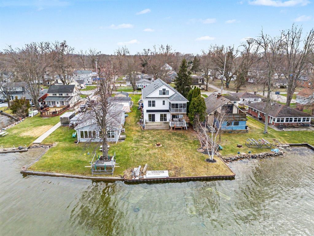 Experience lakeside living on scenic Wamplers Lake with this spacious three-story home offering 7 bedrooms and 4.5 bathrooms, ideal for large gatherings, multi-family use, or a potential short-term rental opportunity. Built in 2019 and set in a prime location just a short walk from Jerry's Pub, the home features an open layout, updated kitchen with stainless steel appliances, and a light-filled living area leading to a lakeside deck with beautiful views. The primary suite includes a private screened porch overlooking the water, while the upper levels provide generous guest space and flexible living options. With 50 feet of frontage, a steel seawall, public utilities, and a 6-car garage, the hard-to-find combination of size, location, and newer construction is already here. The home has been well enjoyed and offers an excellent opportunity for a buyer to add personal touches and maximize its full potential on one of southern Michigan's most popular lakes.