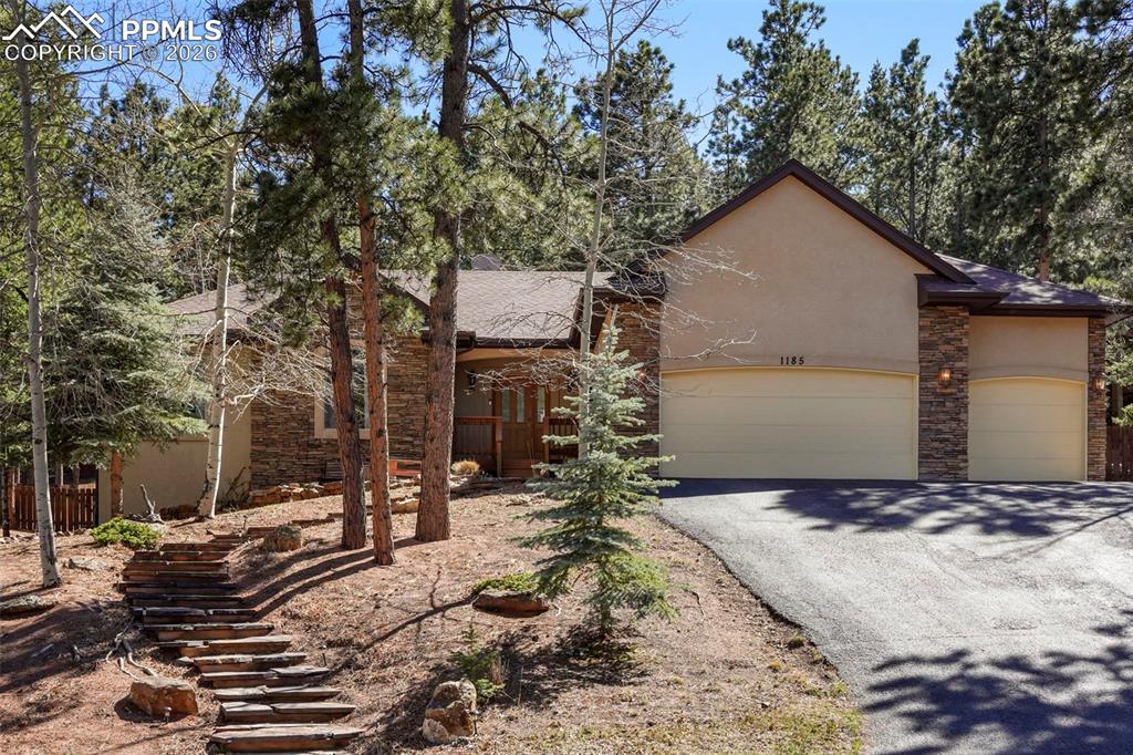 Beautiful mountain home in the pines of Woodland Park, CO. This property offers 3,532 square feet of living space, featuring 5 bedrooms and 3.5 bathrooms. The home is designed for comfortable main-floor living, highlighted by a primary suite that includes a walk-in closet, an attached bathroom, and a walk-out to the back patio. The main floor interior also boasts a cozy fireplace and a bright, inviting kitchen and dining space with another walk-out to the patio. Two additional bedrooms, a full bathroom, a half bathroom, and a laundry room round out the main floor. The garden-level basement contains two generous sized bedrooms and a large family/rec room complete with a wet bar. The home provides ample closet storage space and a 3-car, heated garage. One of the standout features of this property is the outdoor living area. The back patio and deck were added under current ownership and include composite decking and a large, bi-level paver patio and hot tub. For added convenience, there is a gas line connected to the outdoor grill, smoker, and firepit. The backyard is very private, as it borders larger lots and provides a pristine setting for wildlife viewing. Additionally, the home is within walking distance to the local amenities of Woodland Park.