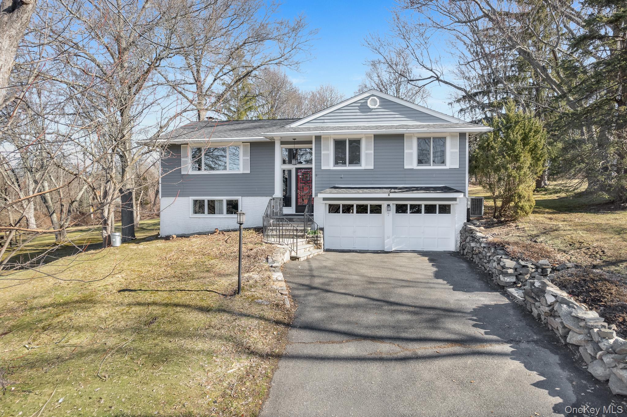A great place to call home, this raised ranch–style home sits on 0.52 acres and provides inviting living spaces in Ossining, just outside the town center. Adding to its appeal, the seller recently installed a brand-new roof, providing an important recent upgrade and added value for the next owner. The foyer leads into a spacious living room with a large bay window that fills the space with natural light. An open layout leads into the formal dining room and continues into a four-season sunroom with oversized windows overlooking the spectacular backyard, creating an ideal setting for get-togethers, summer barbecues, and everyday enjoyment. The space connects seamlessly to the deck, making it easy to enjoy morning coffee or gatherings that move easily between indoors and out. The spacious kitchen features ample cabinetry, granite countertops, a skylight, and a refrigerator designed to blend seamlessly with the cabinetry. The main level includes three generously sized bedrooms and a full bathroom with double sinks. Pull-down attic stairs provide convenient additional storage. The lower level expands the living space with a cozy family room featuring a fireplace, an office or den, a convenient half bathroom, a separate utility room, and direct access to the outdoors. A driveway leads to a two-car garage, completing the property. Ideally located, this home allows you to enjoy the benefits of living in Ossining with close proximity to shopping, dining, parks, and schools, while still feeling removed from the hustle of the town center. Commuters will appreciate easy access to major roadways, including Route 9 and the Taconic Parkway, providing convenient travel throughout Westchester and into New York City.