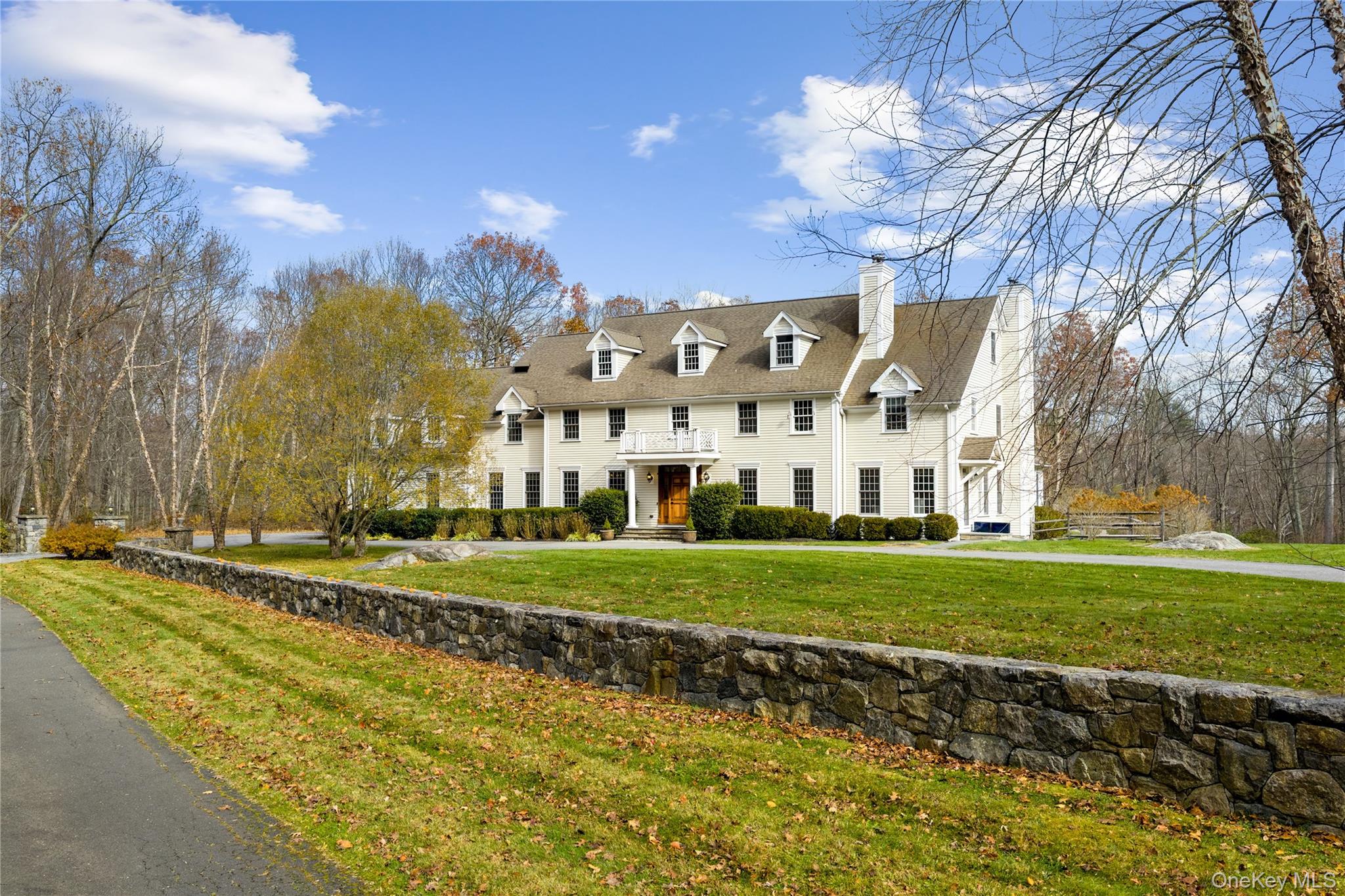 Set on over two spectacular acres in a premier location in Pound Ridge, this custom built Colonial offers an extraordinary blend of scale, craftsmanship, and complete privacy. Tucked along a quiet country road, this home has exquisite architectural detail throughout that includes extensive custom millwork, gleaming hardwood floors, soaring ceilings, and spacious rooms that create an atmosphere of elegance and ease.  Enter through the impressive oversized foyer and immediately sense the grandeur. Sunlight pours through large windows, highlighting the home’s impeccable finishes and thoughtful design. The gourmet kitchen, appointed with granite countertops, opens seamlessly to the expansive living room which is ideal for both intimate gatherings and large celebrations. Additional main level spaces include a formal dining room, front and rear staircases, and a private home office with its own entrance. Upstairs, six spacious bedrooms offer exceptional comfort, each with oversized walk-in closets. Four bedrooms feature en-suite baths, while two share a classic Jack-and-Jill—perfect  guests, or multi-generational living.  Beautiful stone walls, natural rock outcroppings, lush lawns and wooded landscape frame the outdoor spaces. Relax on the expansive stone patio, unwind in the hot tub, or enjoy quiet evenings in the screened porch. There's even ample space for a pool. A semi-circular drive, 3-car garage, large recreation or game room, home gym, five fireplaces and whole-house generator complete this exceptional offering. Located minutes from Pound Ridge’s charming Scotts Corners and convenient to New Canaan, this home combines country serenity with everyday accessibility to shops and restaurants. A true retreat only 50 miles from Manhattan.