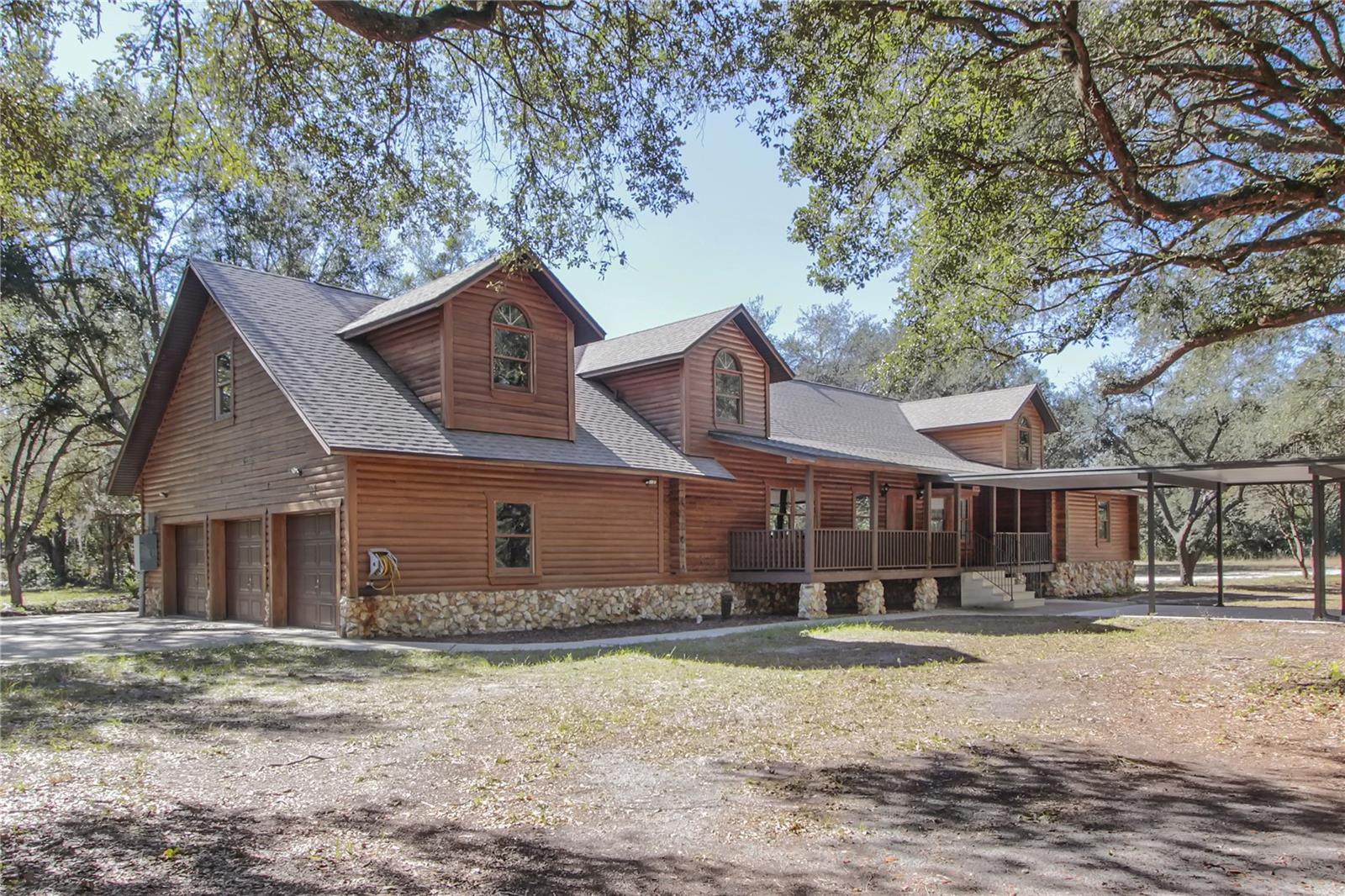 One or more photo(s) has been virtually staged. DISCOVER THE SERENE LUXURY OF THIS METICULOUSLY HANDCRAFTED CYPRESS LOG CABIN, your private and fully fenced 6.11-acre estate in Sorrento, FL. Being offered for the first time, this unique, one of a kind 4,067 SF residence blends rustic charm with modern sophistication, featuring five spacious bedrooms, each with its own private bathroom for ultimate comfort. A bedroom upstairs and a bedroom downstairs have no built-in closet. Pass through the entryway to find Australian Pine floors that flow throughout, while the downstairs primary suite offers a warm Walnut floor, two walk-in closets, and an ensuite with a garden tub and walk-in shower. The heart of the home is the comfortable living room, anchored by a magnificent stone wood-burning fireplace. Culinary enthusiasts will love the country-style eat-in kitchen, boasting extra-thick granite countertops and 42" solid wood cabinets. Sharing the fireplace, a separate sitting room opens to a massive 8’x40’ covered back deck, perfect for relaxing in the gentle Florida breeze. Leading from a spacious bedroom upstairs, a custom-made walkway leads to a versatile landing currently being used as a billiards/game area and a second master bedroom with its own walk-in closet and full bath. Functional highlights include an interior laundry room with a half-bath leading to an oversized 3-car garage. Meticulously maintained, the home was raised 3 feet for longevity and features a New Roof installed in July 2025, an exterior freshly sealed and pest treated in 2025, a New Hot Water Heater in 2025, dual A/C systems from 2022 and 2019, and a New Drain Field from 2020. This property is zoned A-1 with no HOA, offering unlimited potential for an accessory dwelling, gardening or horses & farm animals or use as a boutique Bed & Breakfast with a special exception. Enjoy unparalleled peace and privacy while remaining minutes from the 429, Mount Dora, Orlando, and Florida's famous beaches. This unique, one-owner cypress sanctuary is a rare find — experience it for yourself today!