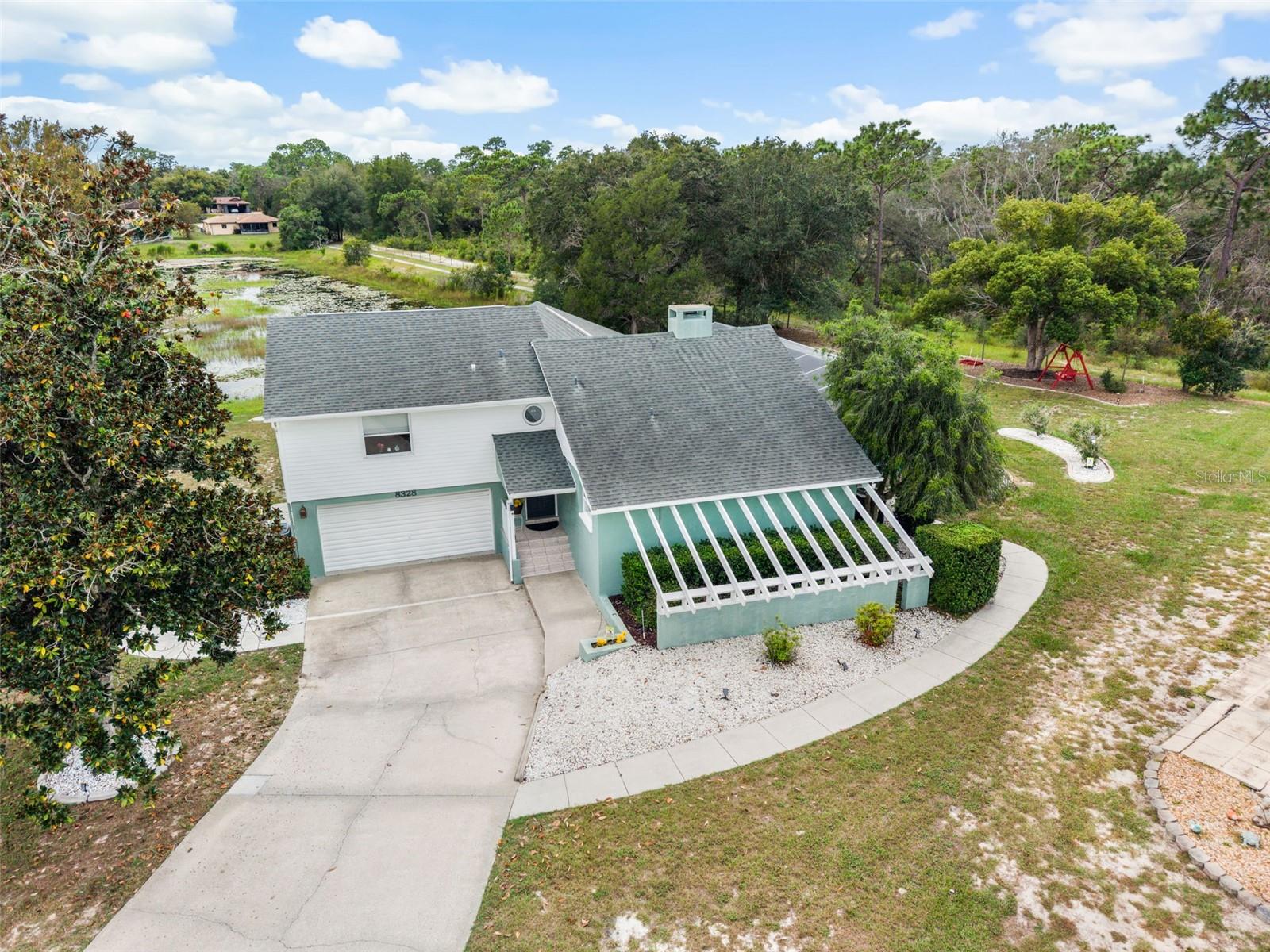 A Nature Lover's Dream: Expansive Half-Acre Waterfront Retreat Backing onto Nature PreservesIf you've been looking for true privacy, elbow room, and real Florida nature, you know homes like this is a rare find.  Sitting on a rare half-acre lot—one of the largest in the entire neighborhood—8328 Dunnellon Rd backs right up to protected preserve land with its own quiet pond right in the backyard. No rear neighbors, just trees, water, and wildlife.From the moment you walk in, the home feels open, bright, and calm. High ceilings and large windows pull the outdoor scenery inside, and three massive sliding glass doors flood the entire main living space with natural sunlight. The centerpiece of the living room is a gorgeous double-sided fireplace that shares warmth and character with the primary bedroom on the other side.The layout is smart and versatile. The primary suite is privately tucked on the main floor, complete with plenty of closet space, a dedicated office area, and an en-suite bath with a large walk-in shower. Upstairs, you’ll find two more bedrooms and a full bath with a jetted tub. One of the upper bedrooms even has its own private balcony looking out over the water. Whether you have teens, frequent out-of-town guests, or need a comfortable setup for multi-generational living, this floor plan gives everyone their own distinct space.Outside is where you will spend most of your time. The enclosed lanai is the go-to spot for morning coffee, looking out over the pool, the lake, and the preserve beyond. The screened pool enclosure is outfitted with fine no-see-um mesh, and the huge deck leaves plenty of room for grilling, entertaining, or simply lounging without bugs getting in the way.  Bring your toys, too. The oversized two-car garage is way bigger than standard and features an ultra-convenient pull-through door—making it effortless to store and maneuver your boat, trailer, golf cart, or weekend project with easy backyard access.  You’re just minutes from the Weeki Wachee River, local boat ramps, dining, and shopping, yet at home it feels worlds away from everything.Bonus for qualified buyers: This property is eligible for 100% USDA financing with zero down! (Buyer to verify eligibility with lender.)Come walk the grounds and see the views for yourself—schedule your private tour today.