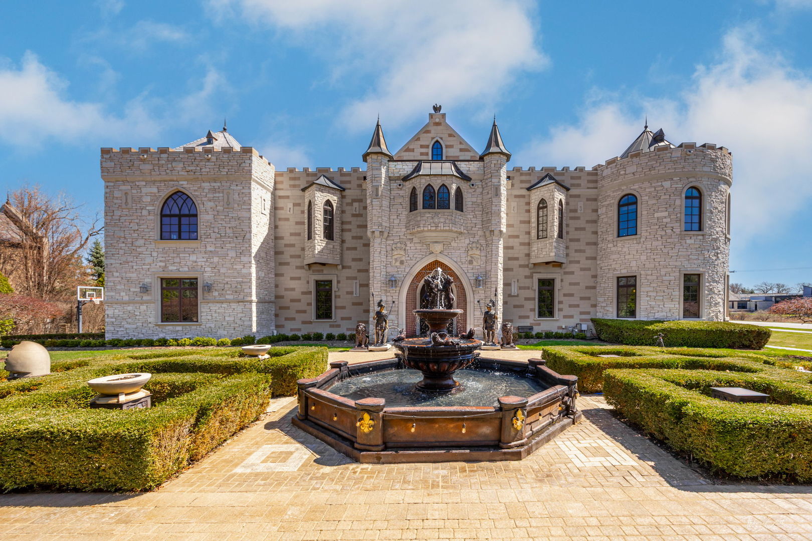 An iconic architectural statement in the heart of prestigious Oak Brook, this extraordinary fortress-inspired estate - widely known as the "Castle House" - offers a rare opportunity to own one of the most distinctive luxury residences in Illinois.    Masterfully constructed with uncompromising masonry craftsmanship, the home showcases dramatic stone and brick detailing, reinforced concrete construction, and impressive 18-inch thick exterior walls designed for lasting strength, privacy, and quiet elegance. From the moment of arrival, the residence delivers a commanding presence unlike anything else in the suburban luxury market.      Spanning approximately 12,000 square feet, the estate was thoughtfully designed for grand-scale living and entertaining. A breathtaking great room with soaring 40-foot ceilings and skylights illuminating an interior courtyard creates a striking architectural centerpiece. Throughout the home, refined finishes, imported wrought iron accents, and expansive gathering spaces reflect a commitment to timeless design and craftsmanship.      Five private bedroom suites, including a substantial primary retreat, provide exceptional comfort and privacy. Radiant heated floors and a private elevator ensure convenience across all levels. Multiple fireplaces add warmth and sophistication to both formal and relaxed living areas.    The fully finished lower level delivers a complete lifestyle experience featuring a theater room, game and recreation areas, fitness space, wine cellar, and entertaining bar - ideal for hosting intimate gatherings or large celebrations. The rooftop presents additional potential for a custom outdoor deck or lounge, offering yet another opportunity to elevate this already remarkable residence.      Situated in one of Chicagoland's most prestigious communities, this one-of-a-kind property is perfectly suited for a discerning buyer seeking scale, distinction, and the chance to personalize a true legacy estate.    This is more than a home - it is a landmark opportunity to own a residence that commands attention and tells a story.